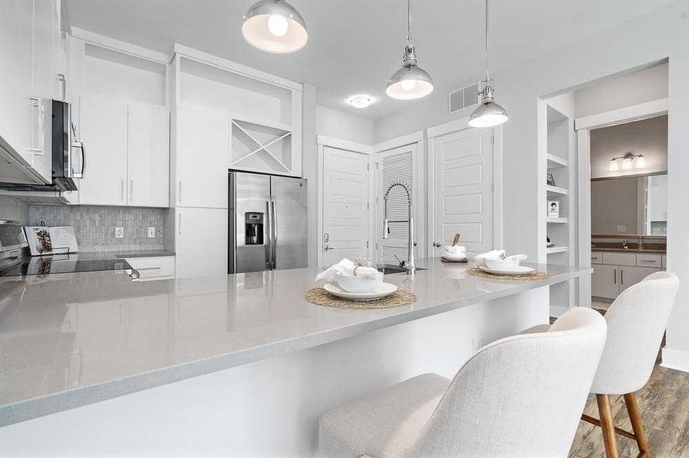 a white kitchen with white chairs and a counter top
