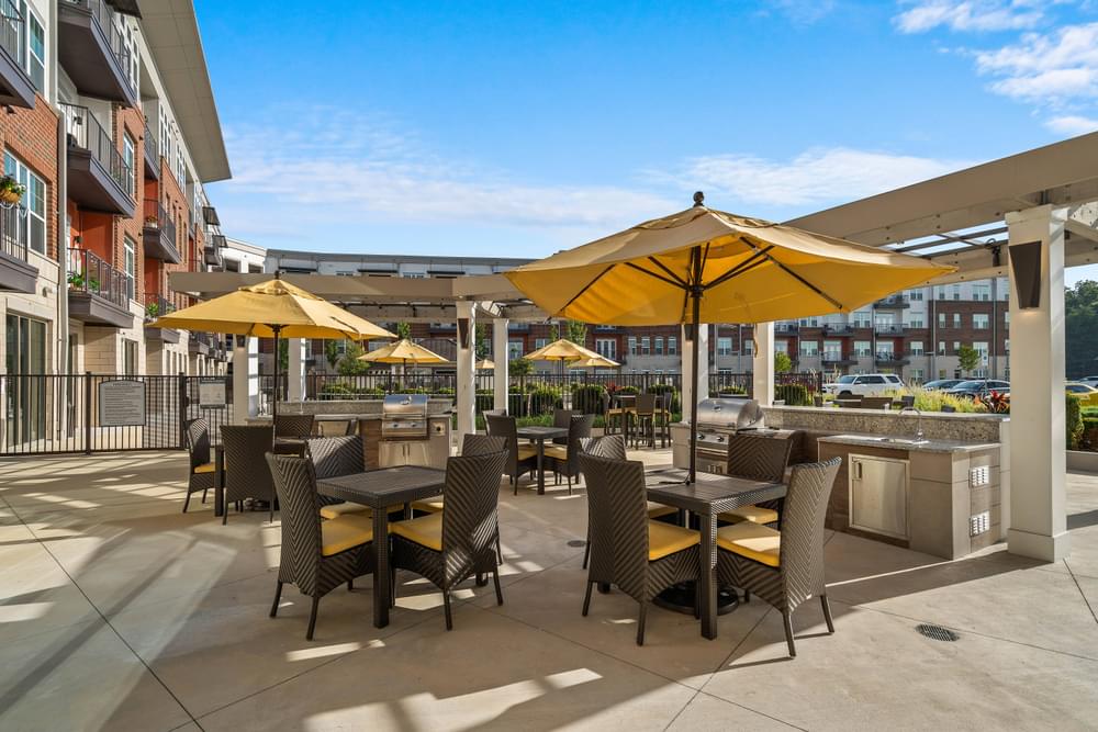 an outdoor patio with tables and umbrellas at the residences