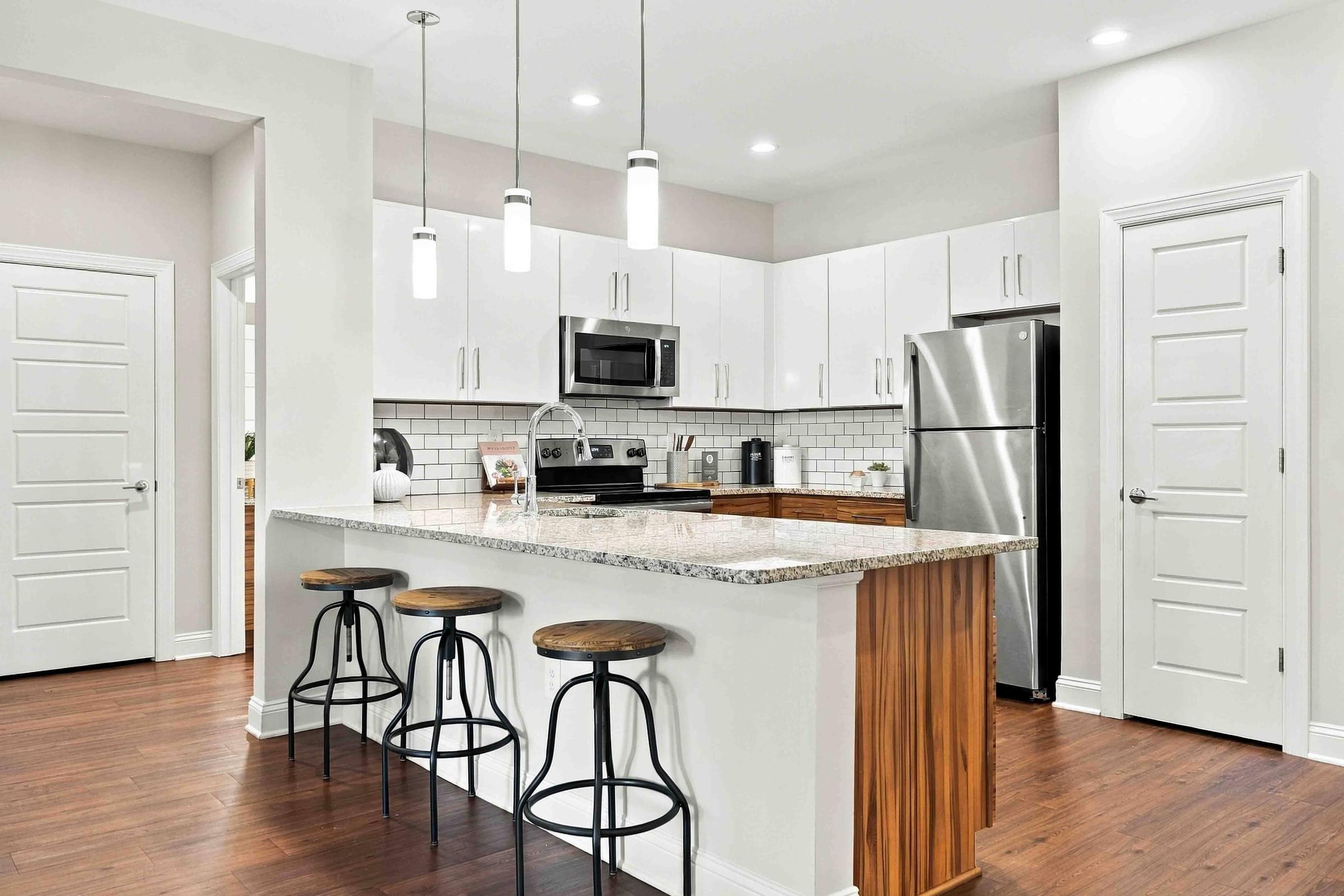 A kitchen with a white counter top and a refrigerator.