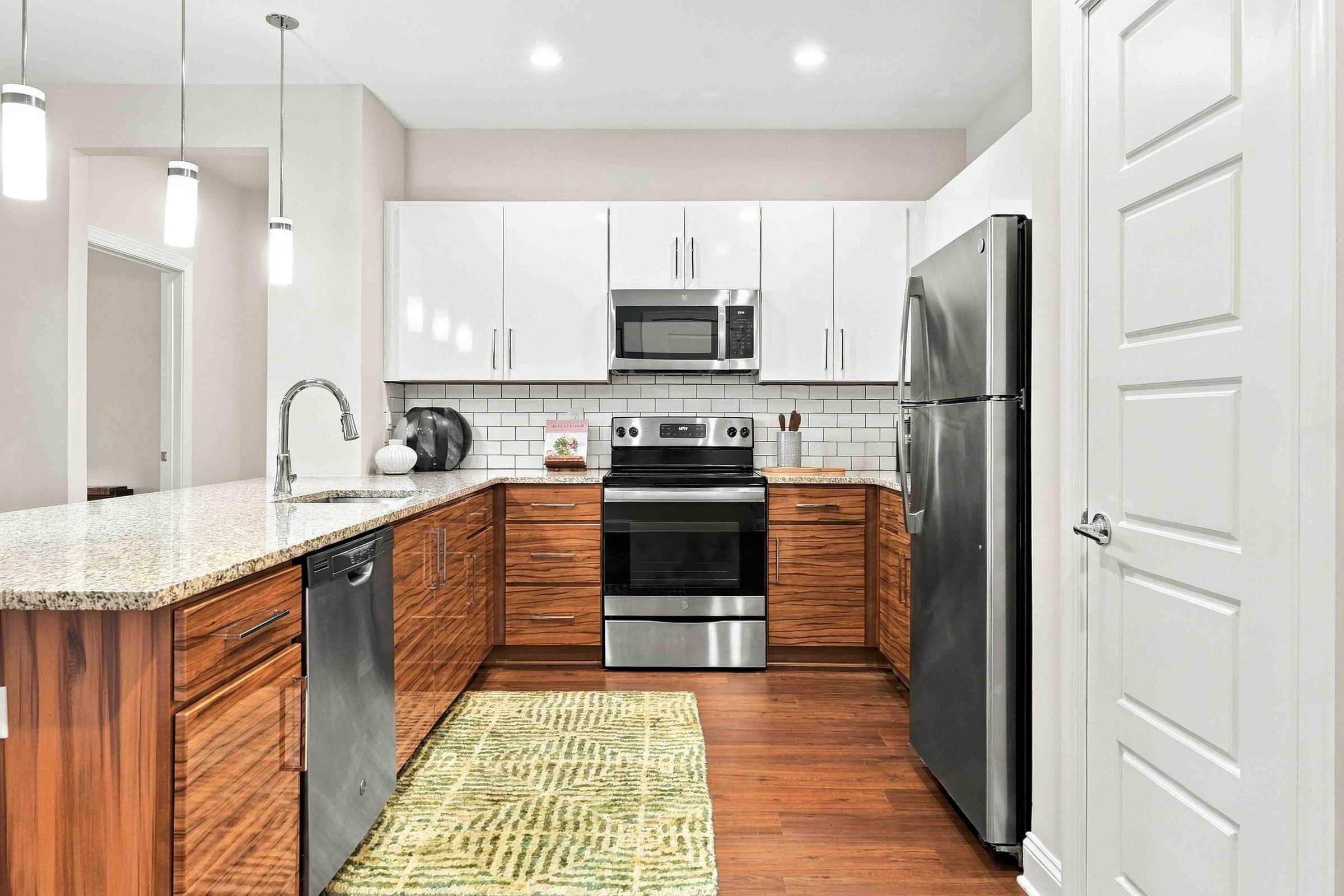 A modern kitchen with a refrigerator, sink, and oven.