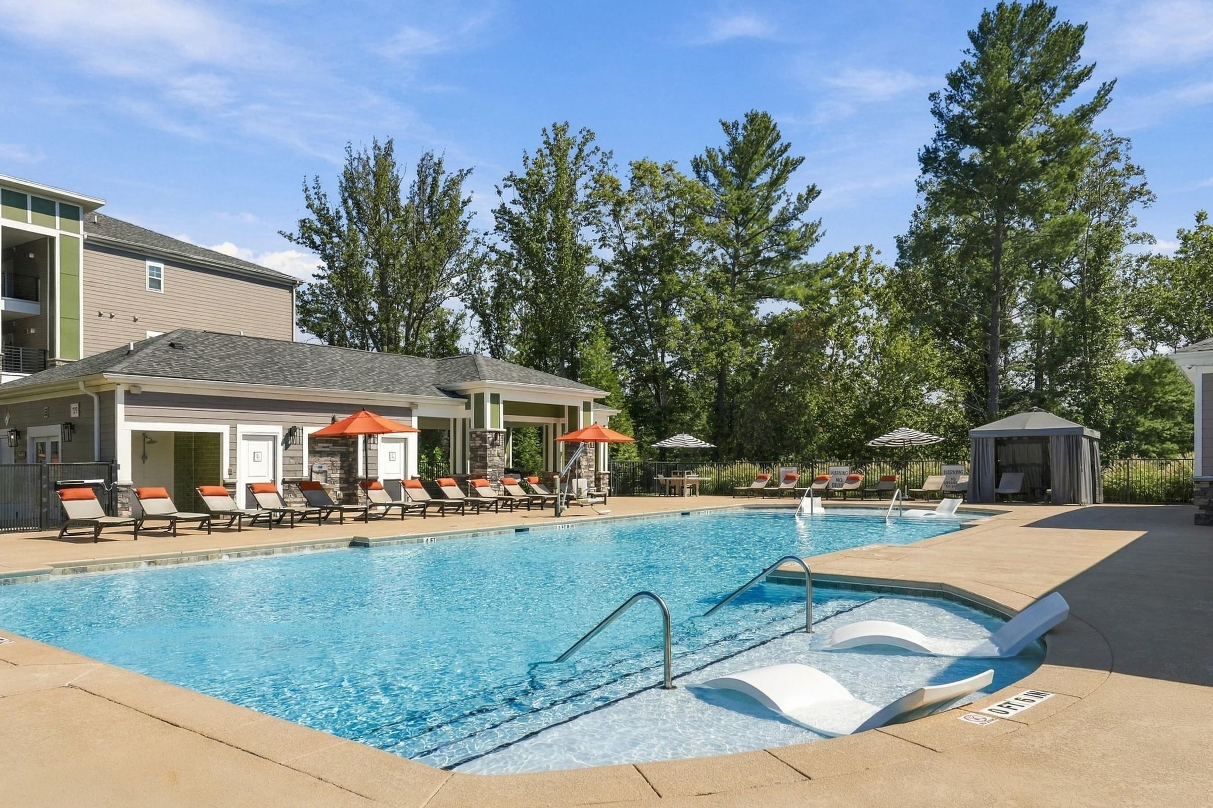 A swimming pool with a slide and sun loungers.