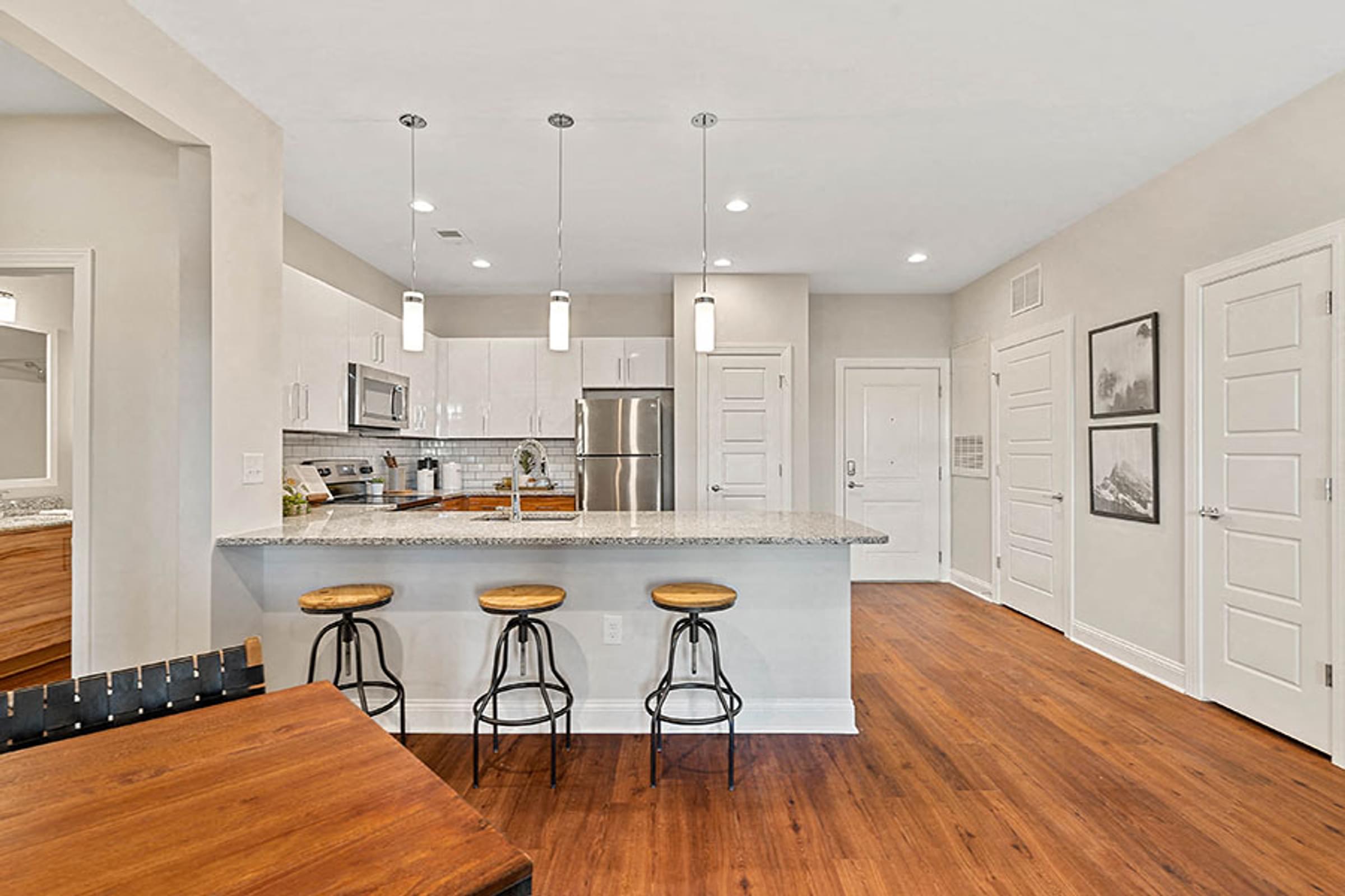 an open kitchen with an island and bar with stools