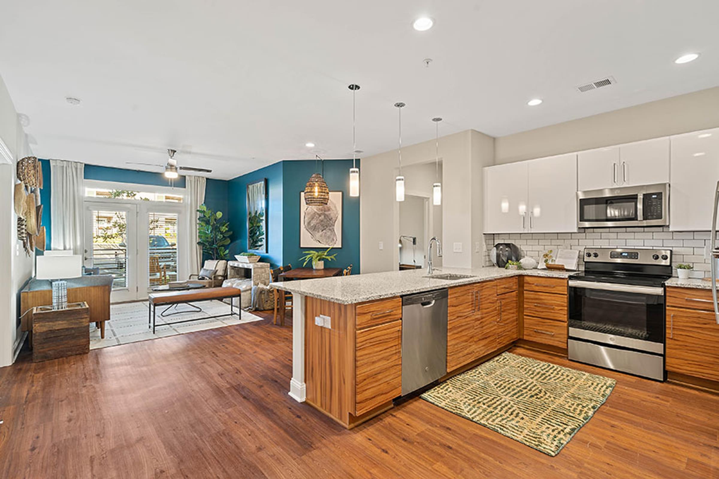a large kitchen with an island and a living room