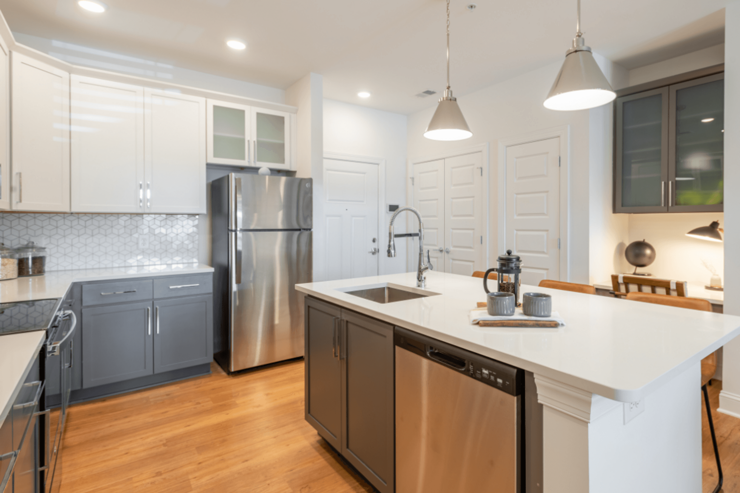 a kitchen with a white counter top and a stainless steel refrigerator