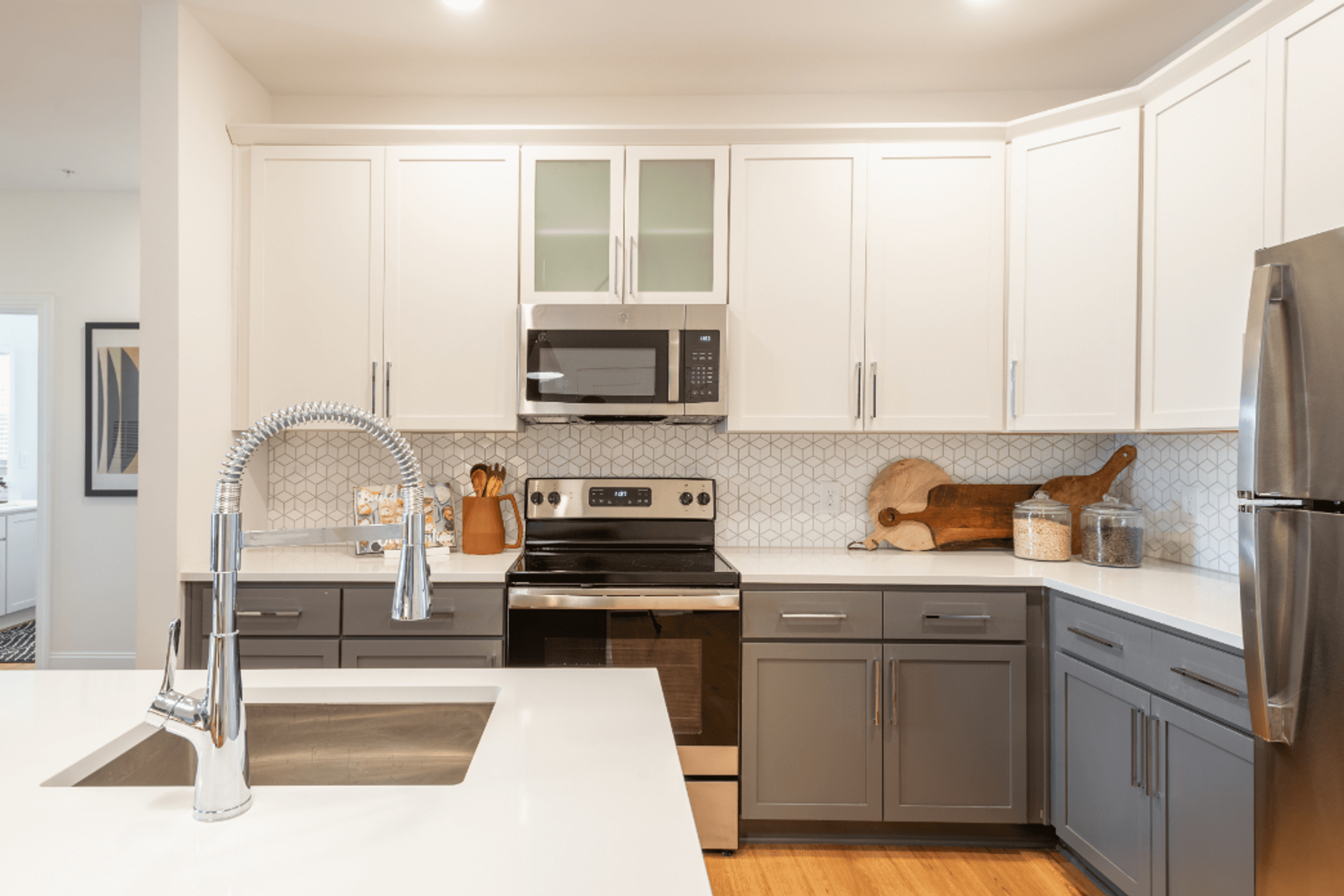 a kitchen with white counter tops and gray cabinets