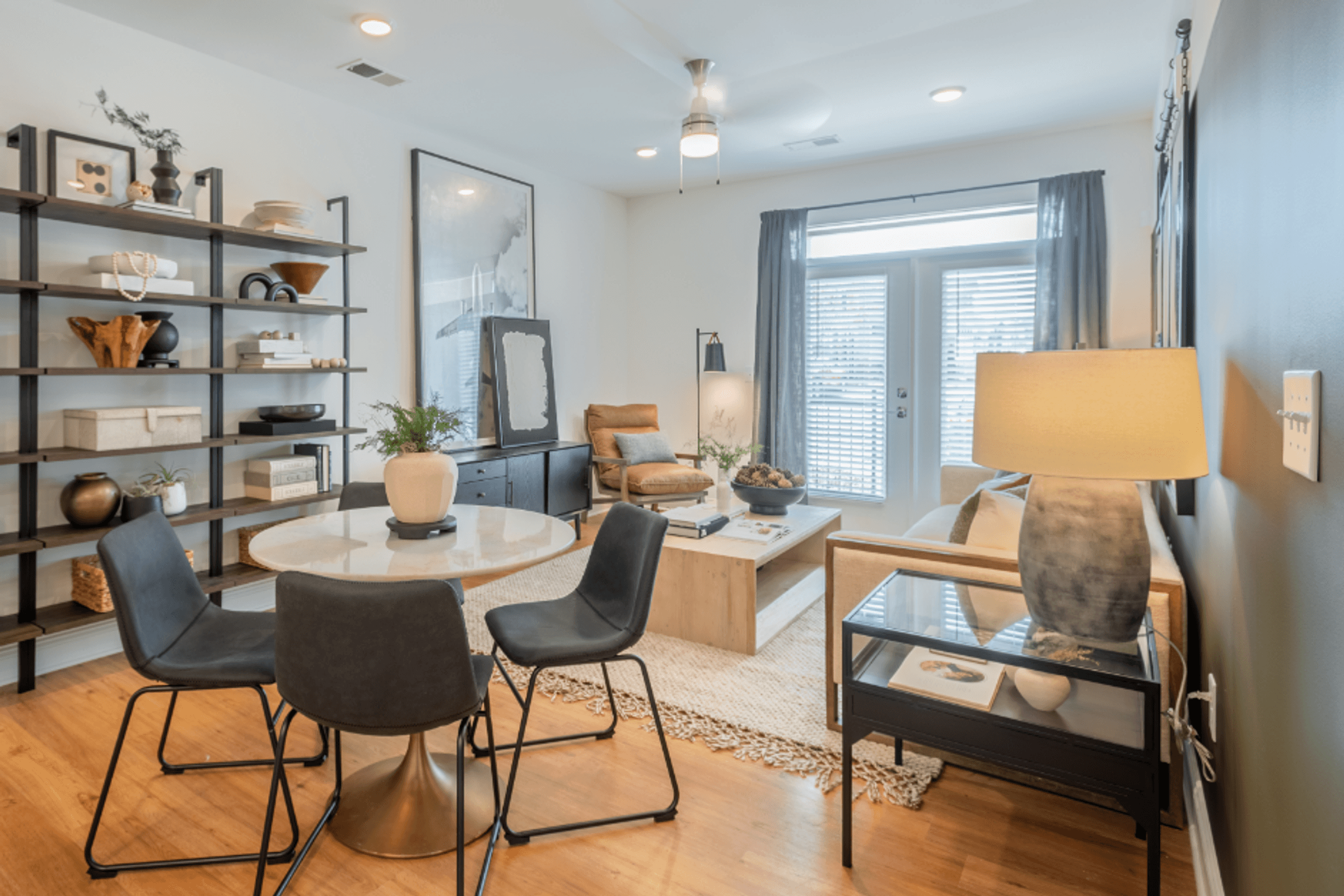a living room with a table and chairs and a window
