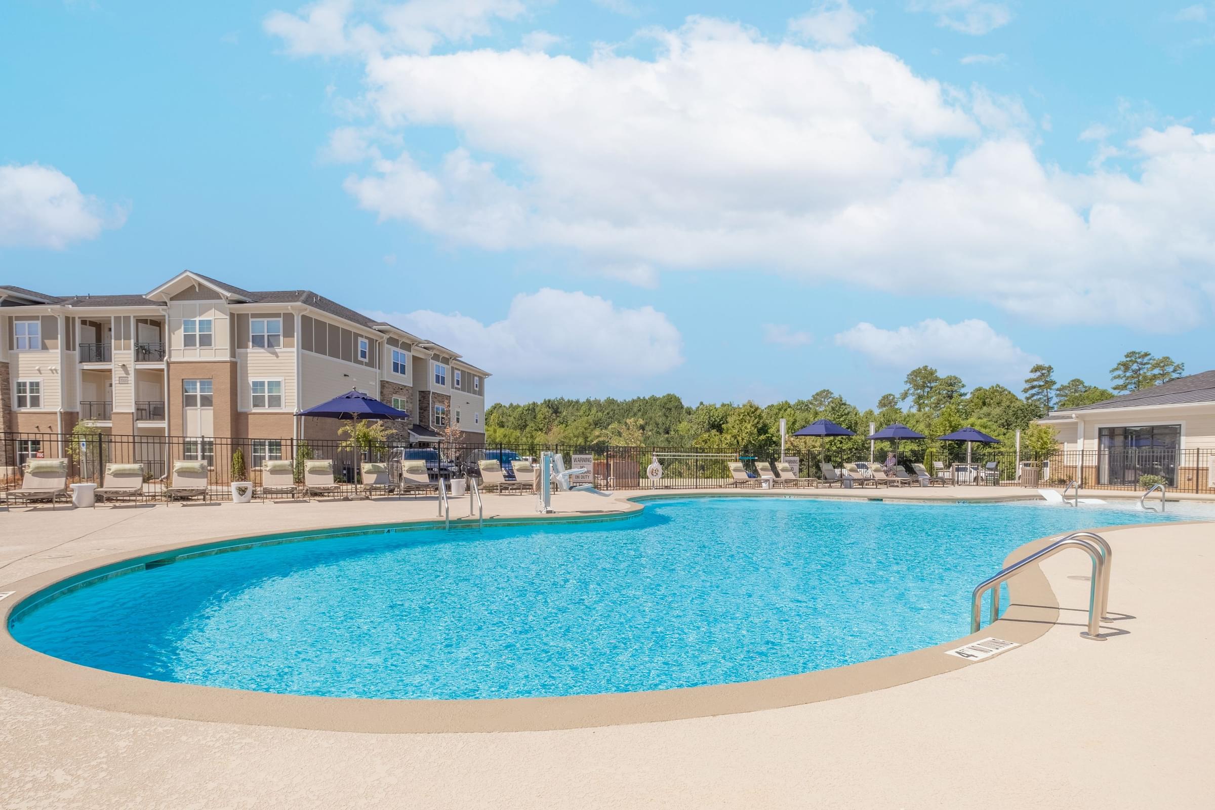 a swimming pool with an apartment building in the background