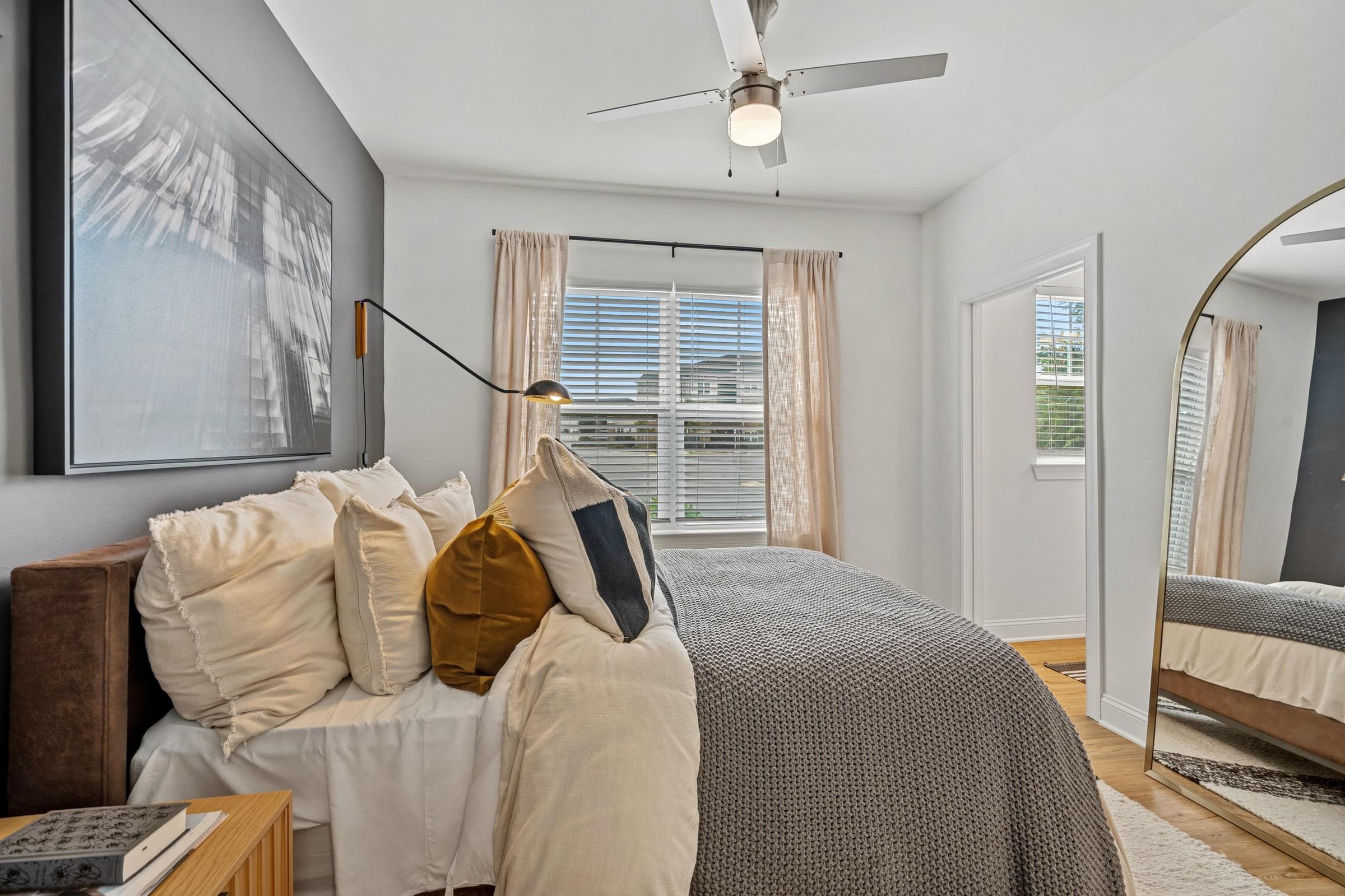 A bedroom with a large bed and a ceiling fan.