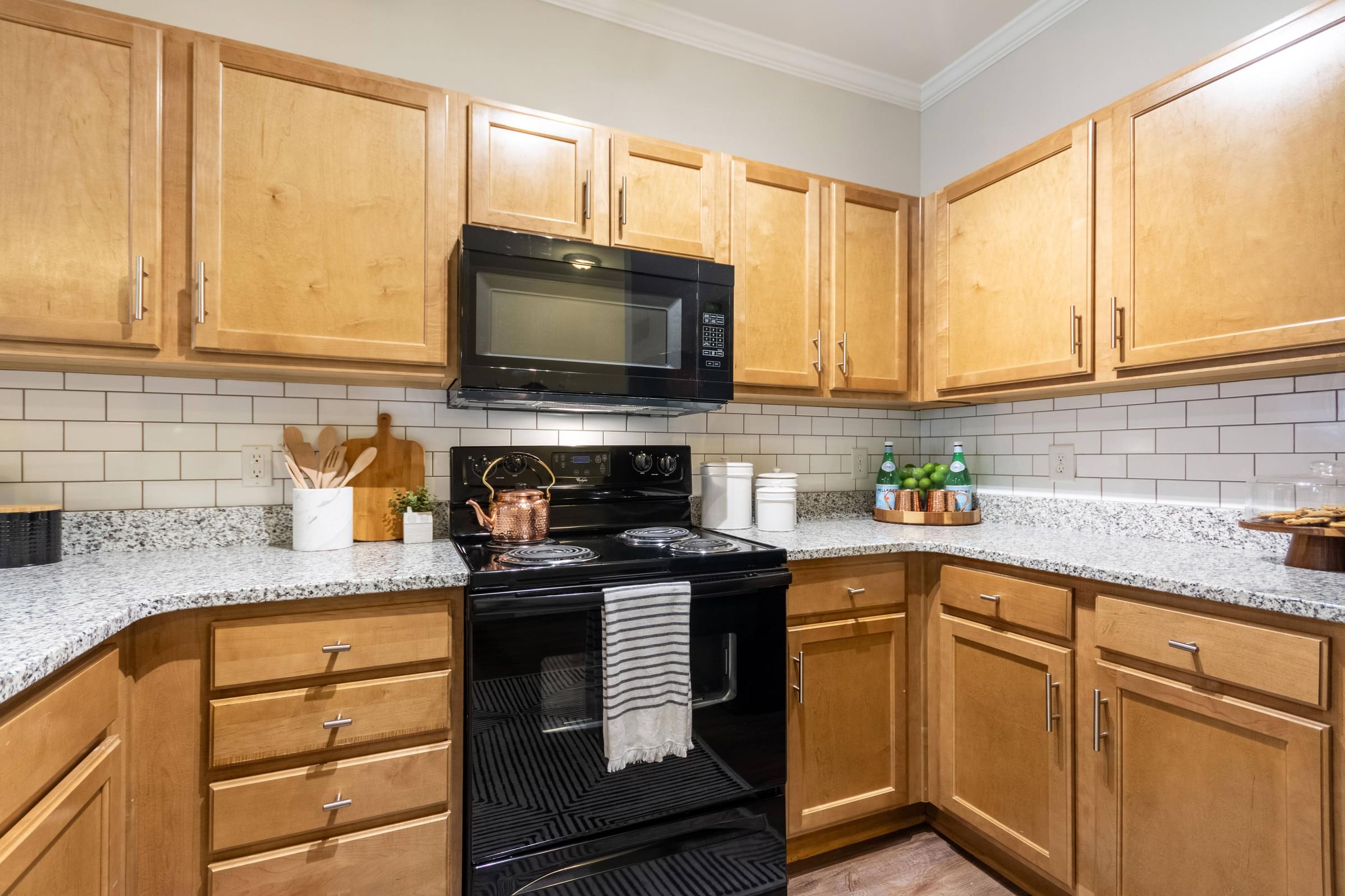 A kitchen with wooden cabinets and a black stove top.