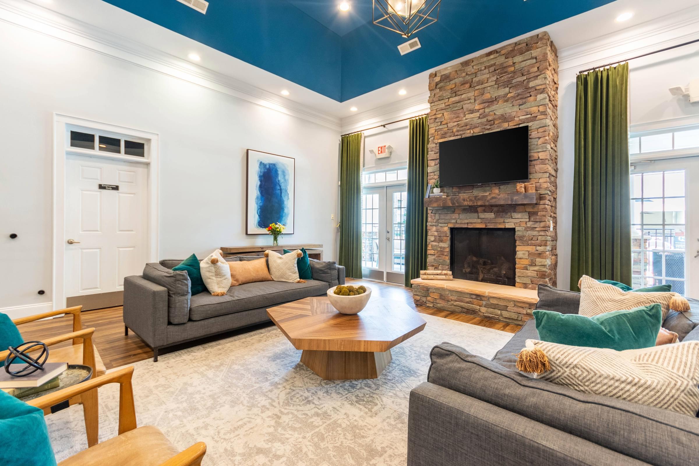A living room with a grey couch, a wooden coffee table, and a stone fireplace.