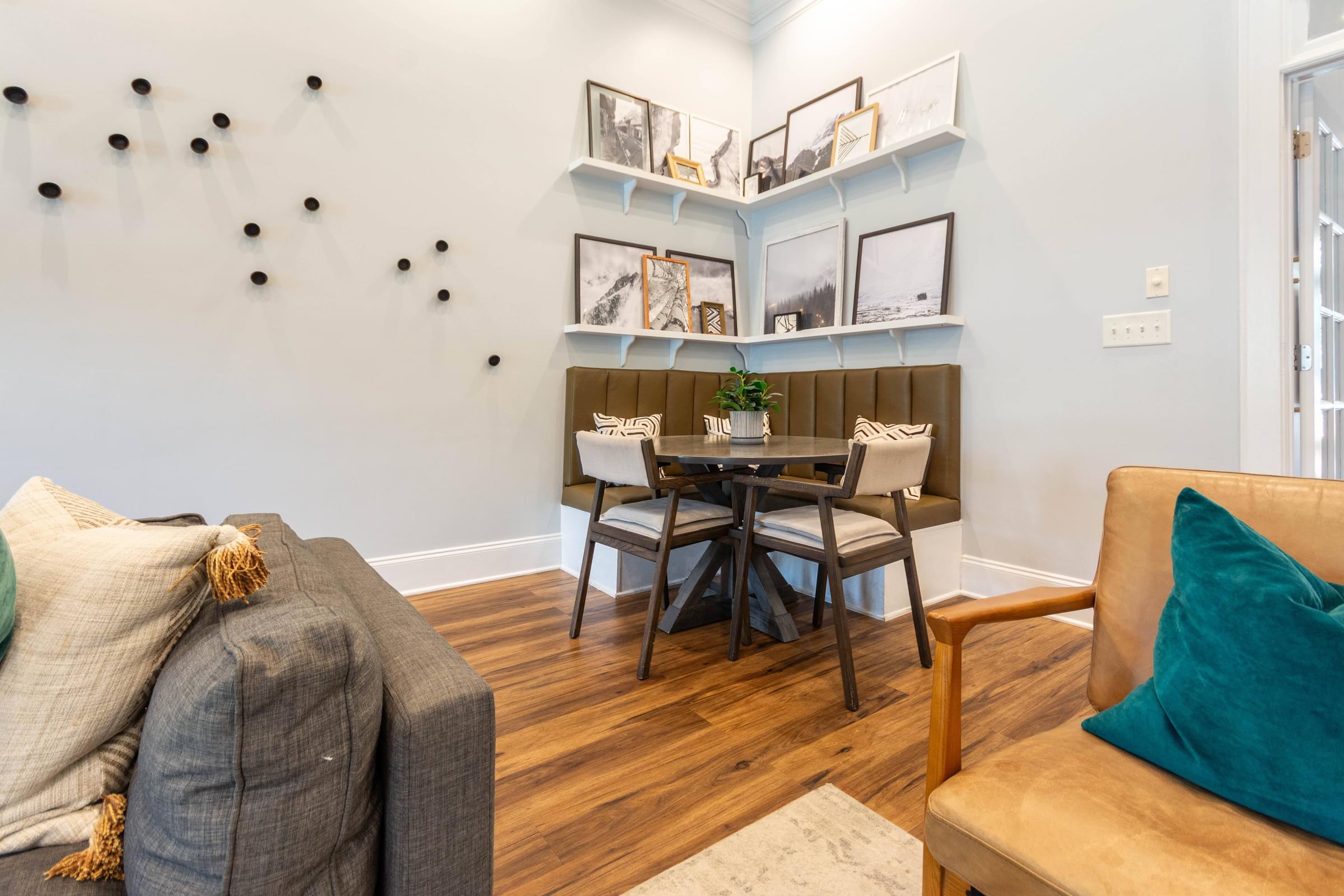 A living room with a grey couch and a wooden chair.