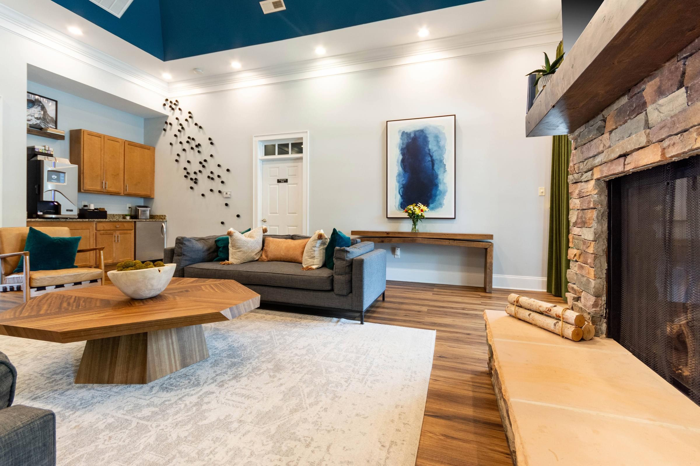 A modern living room with a fireplace and a painting on the wall.
