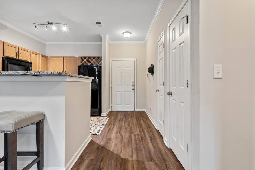 the view of a hallway with a kitchen and a door to the living room