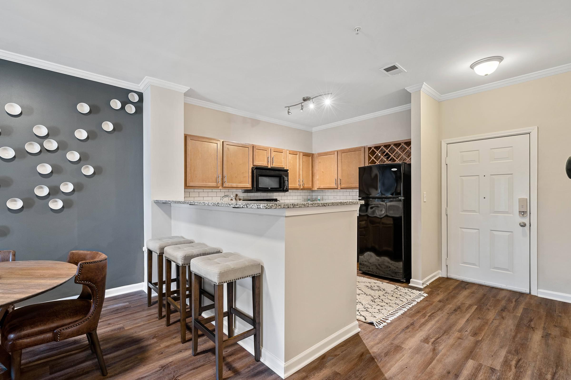 a kitchen with a bar with three stools
