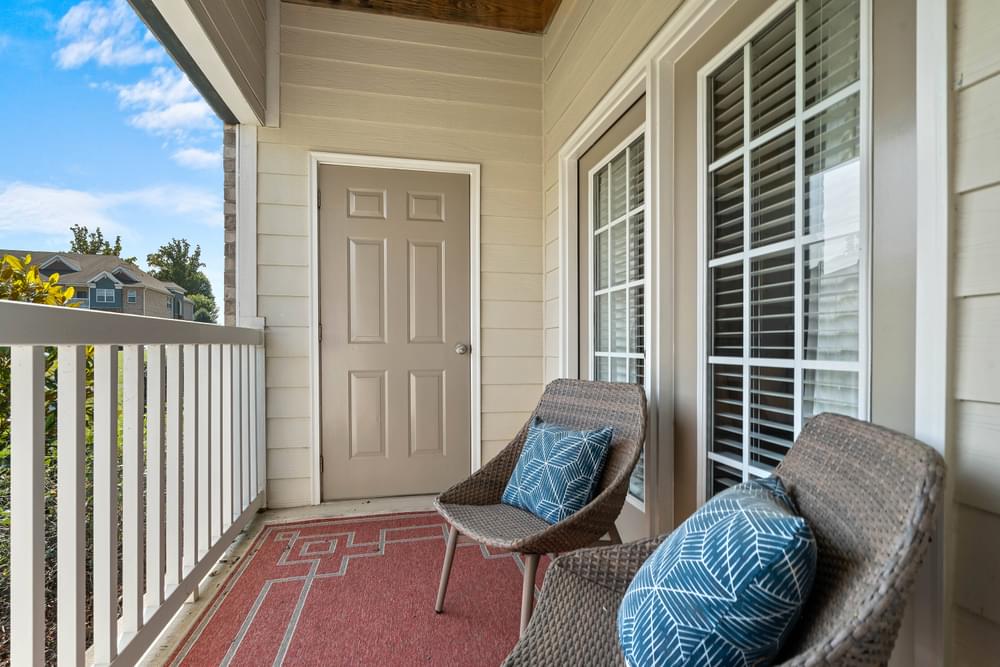 a front porch with two chairs and a door