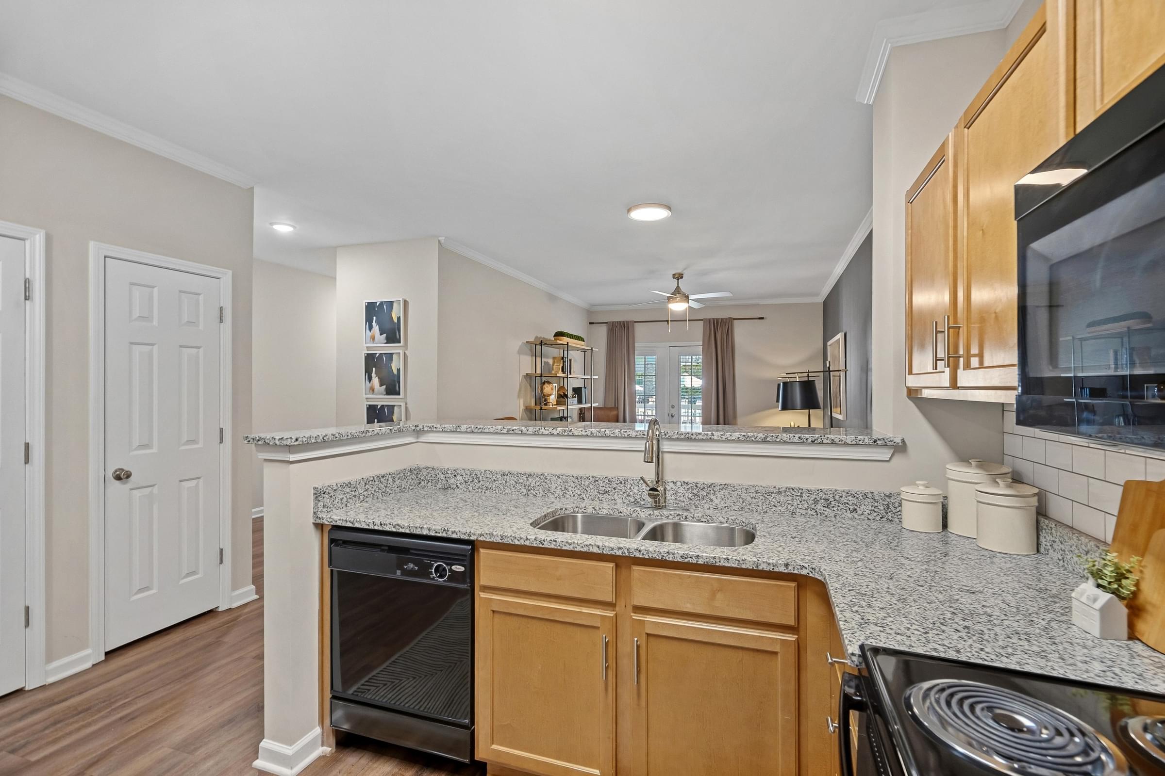 A kitchen with a granite countertop and wooden cabinets.