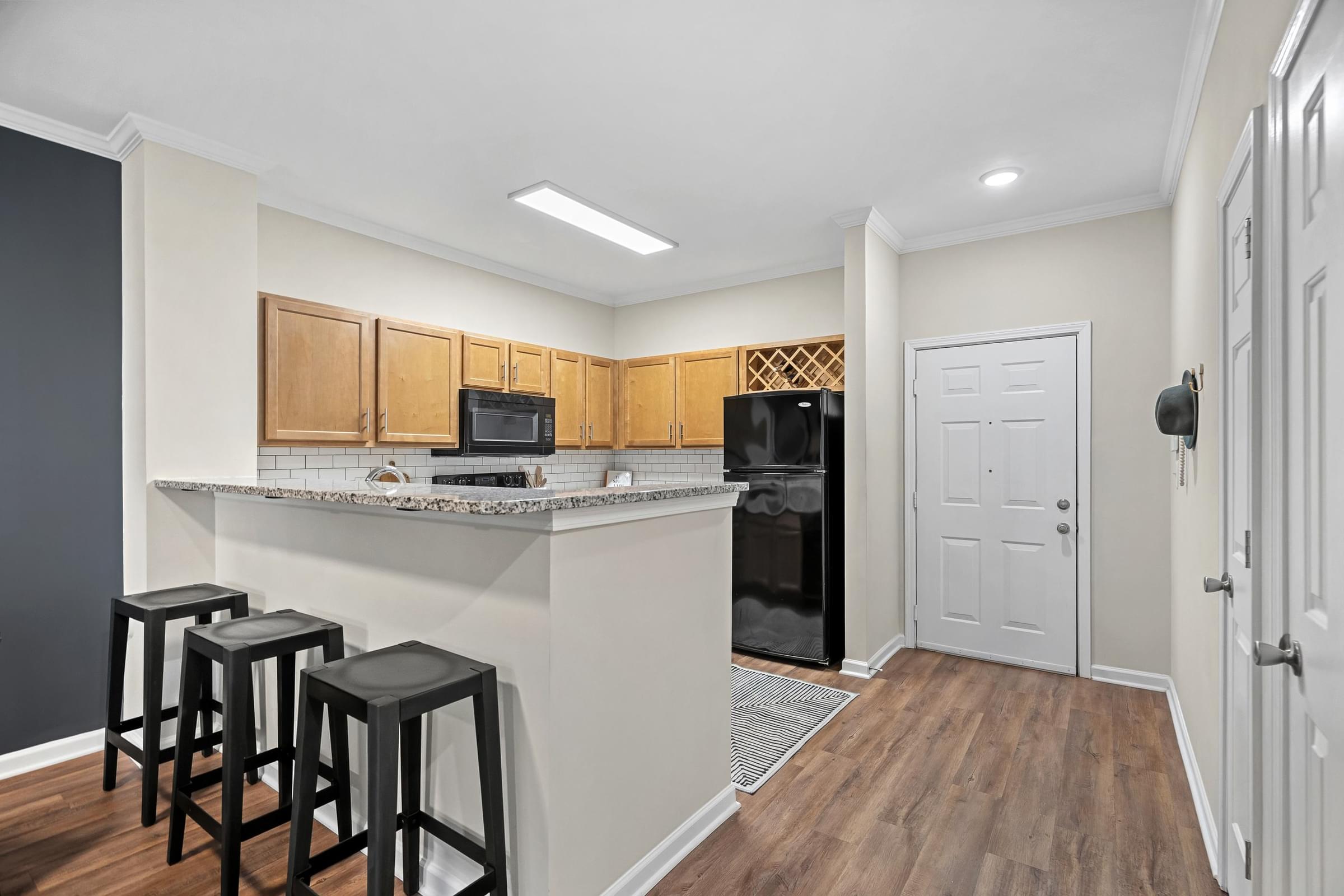 A kitchen with a bar area and a refrigerator.