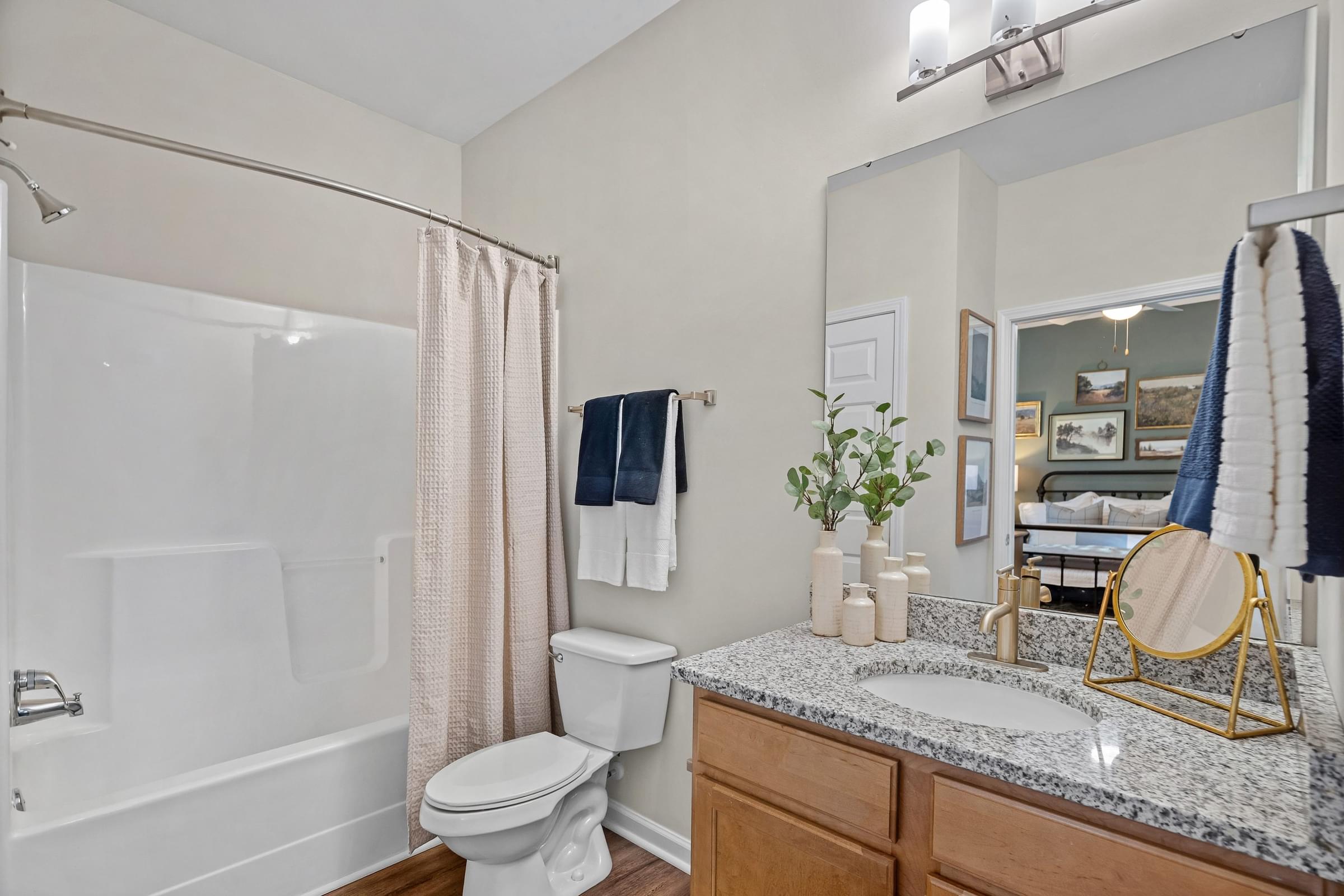 A bathroom with a white toilet, sink, and shower.