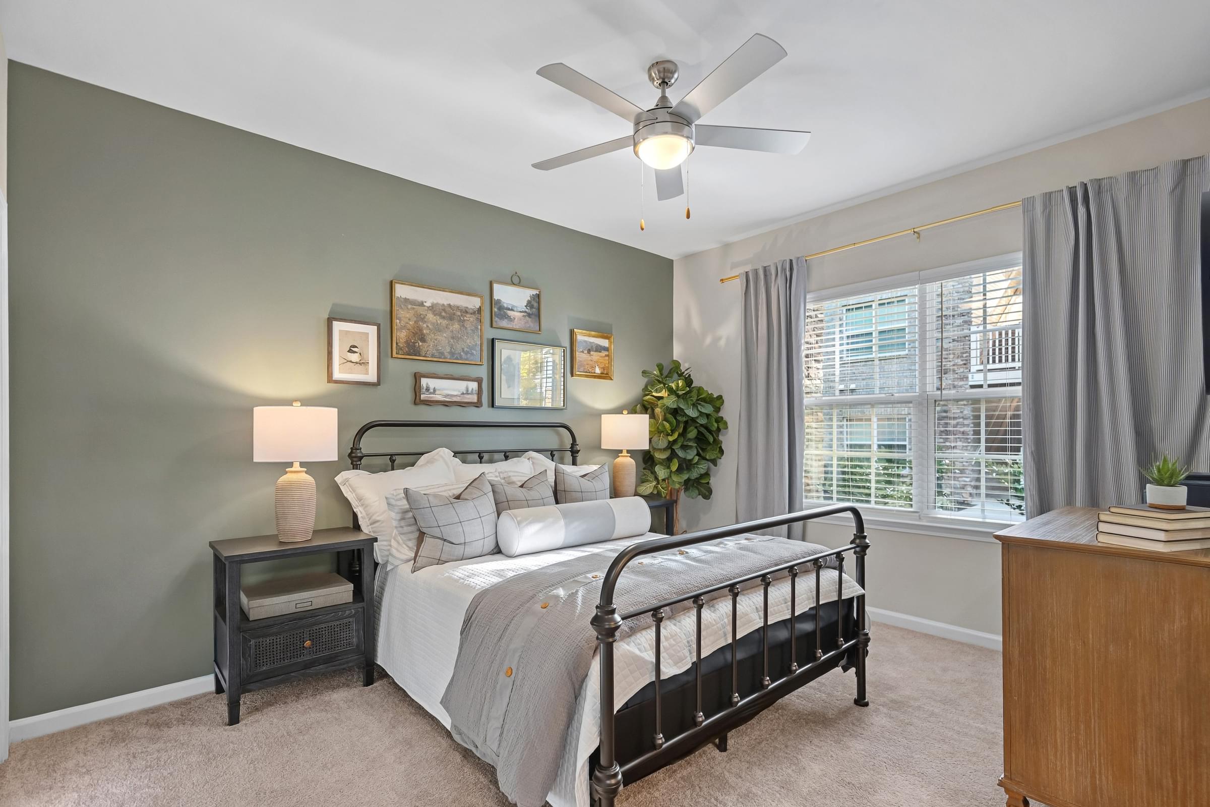 A bedroom with a bed, nightstand, and a ceiling fan.
