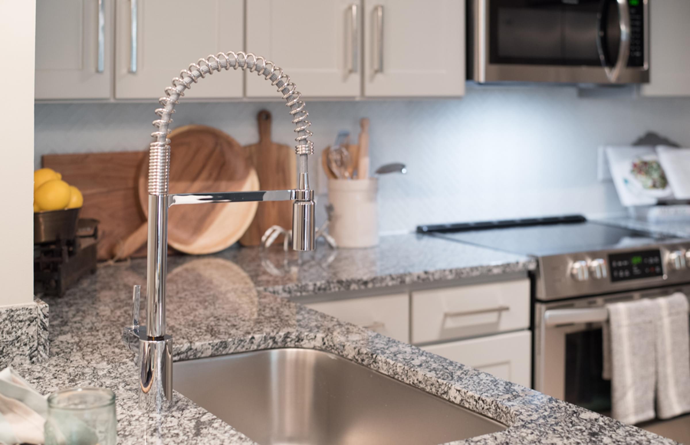 A kitchen with a granite countertop and stainless steel appliances.