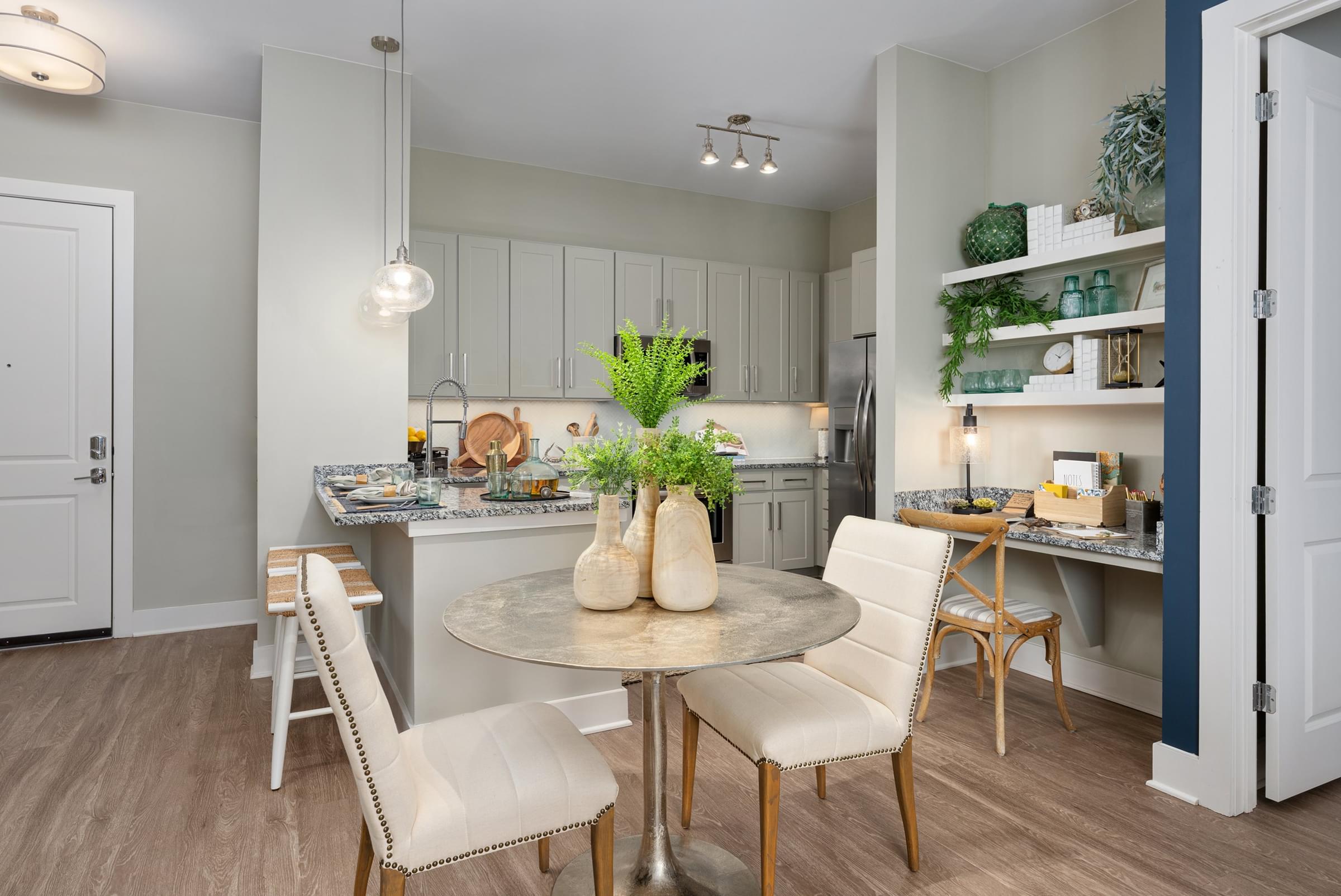 A kitchen with a table and chairs in the foreground.