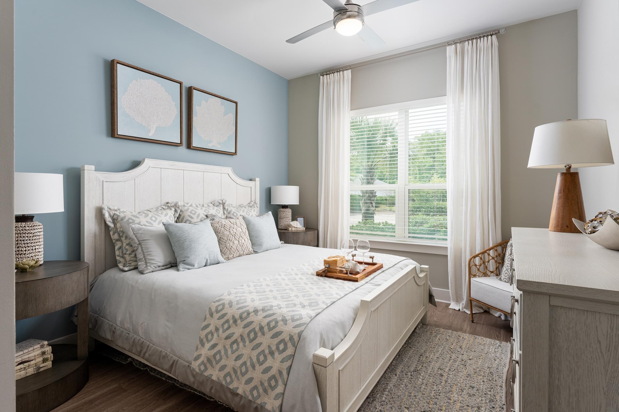 A bedroom with a large bed and a ceiling fan.