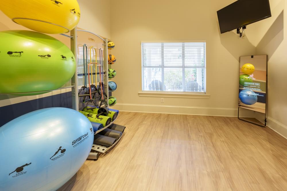 a gym with a bunch of exercise equipment and a window