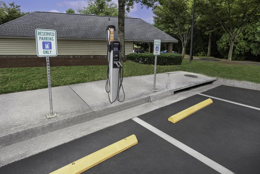 a gas pump in a parking lot in front of a house