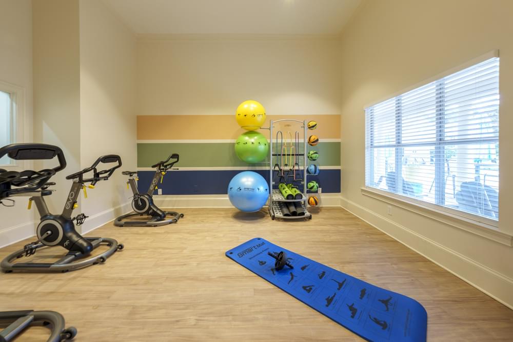 a home gym with exercise equipment and a window