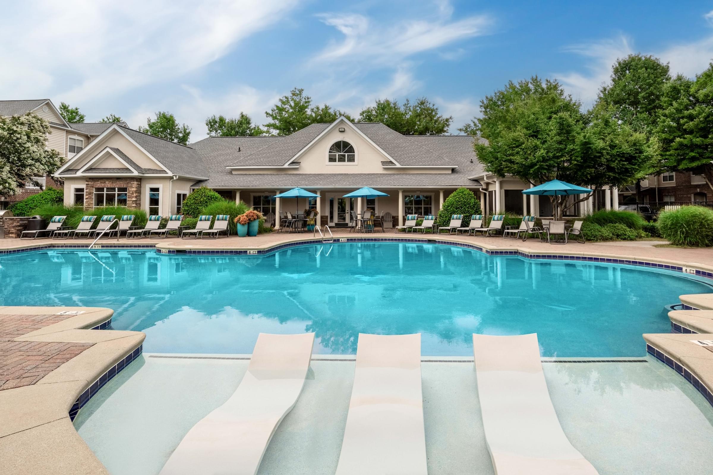 the preserve at ballantyne commons community swimming pool with lounge chairs and a house