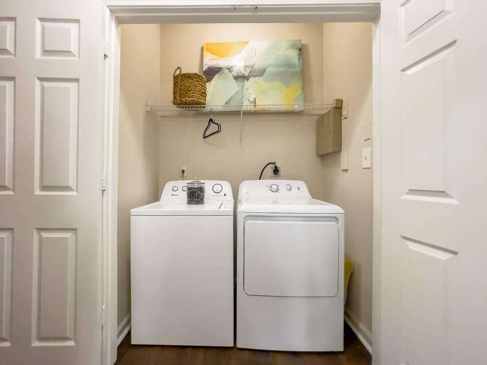 a white washer and dryer in a laundry room with white doors