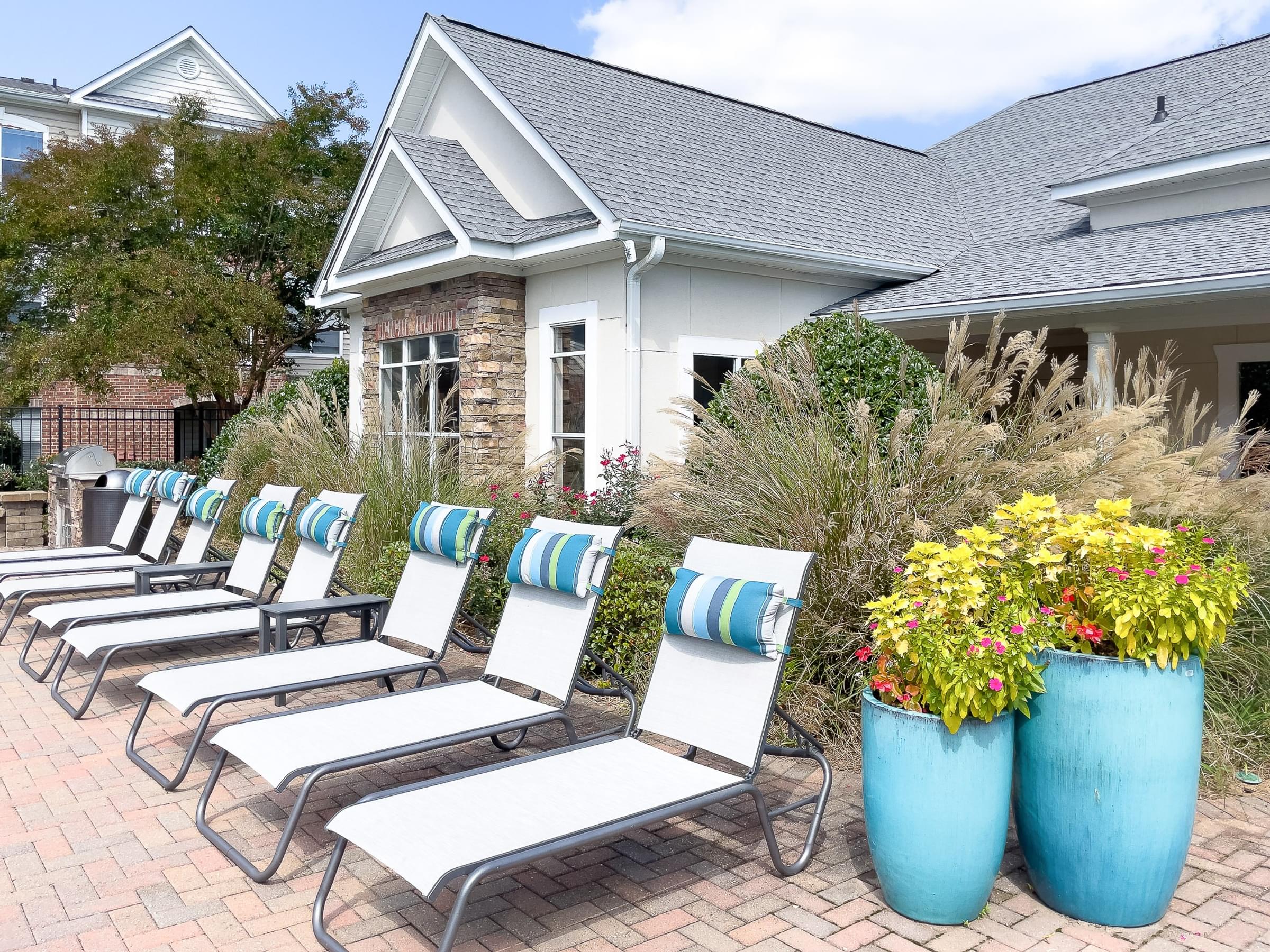 a row of lawn chairs in front of a house