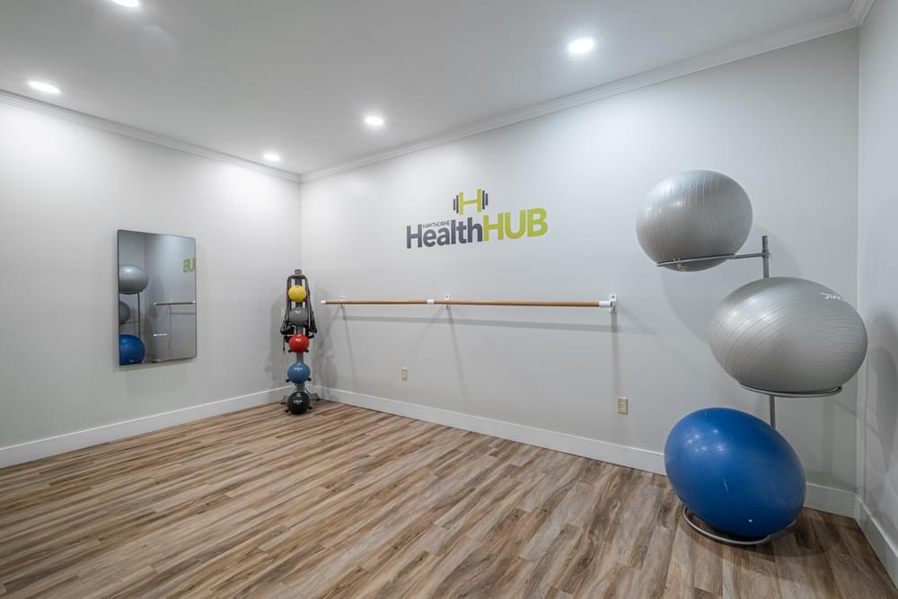 a gym with a yoga ball and a health hub sign on the wall