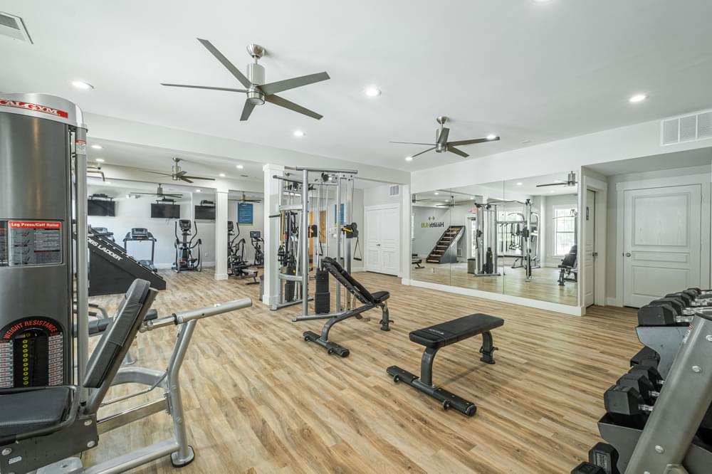a home gym with weights and cardio equipment on a wooden floor