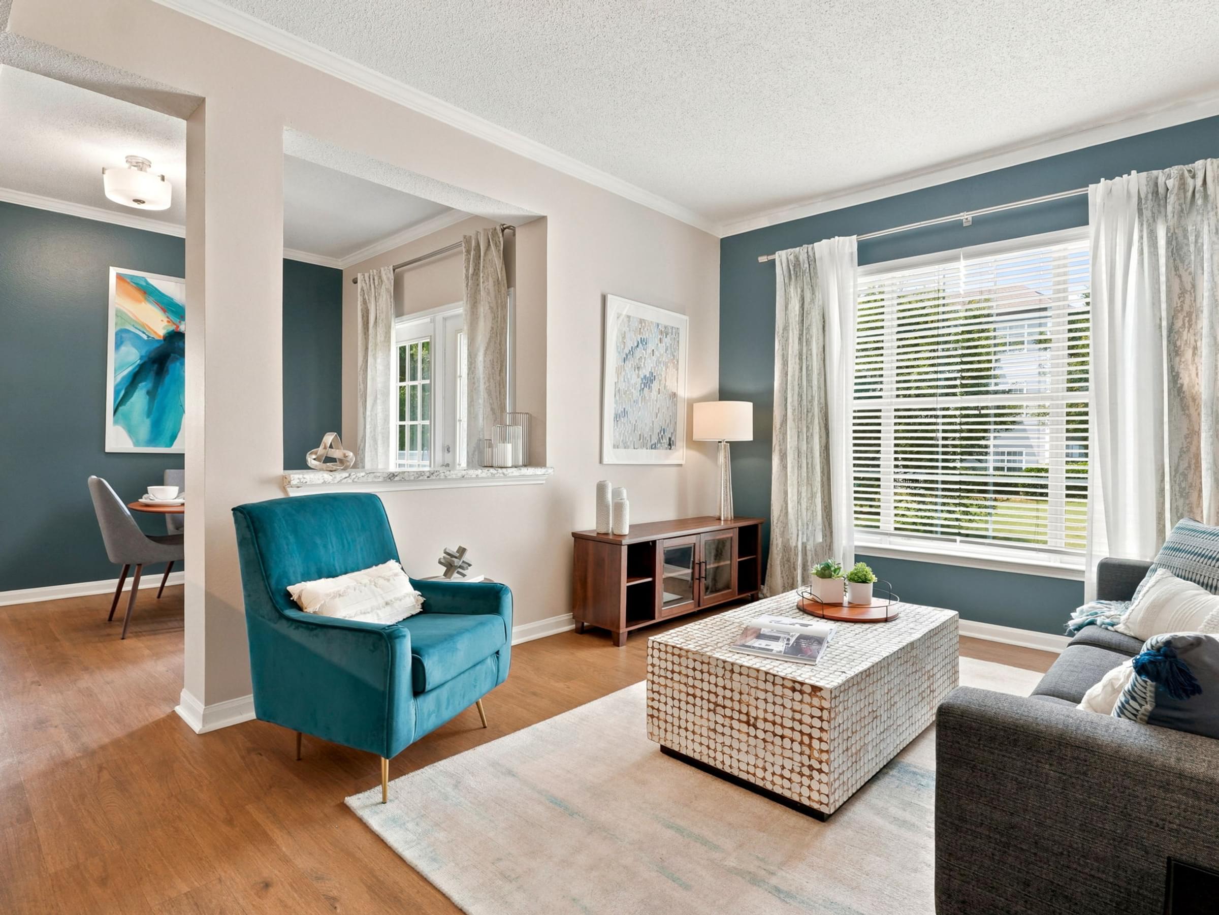A living room with a blue chair and a grey couch.