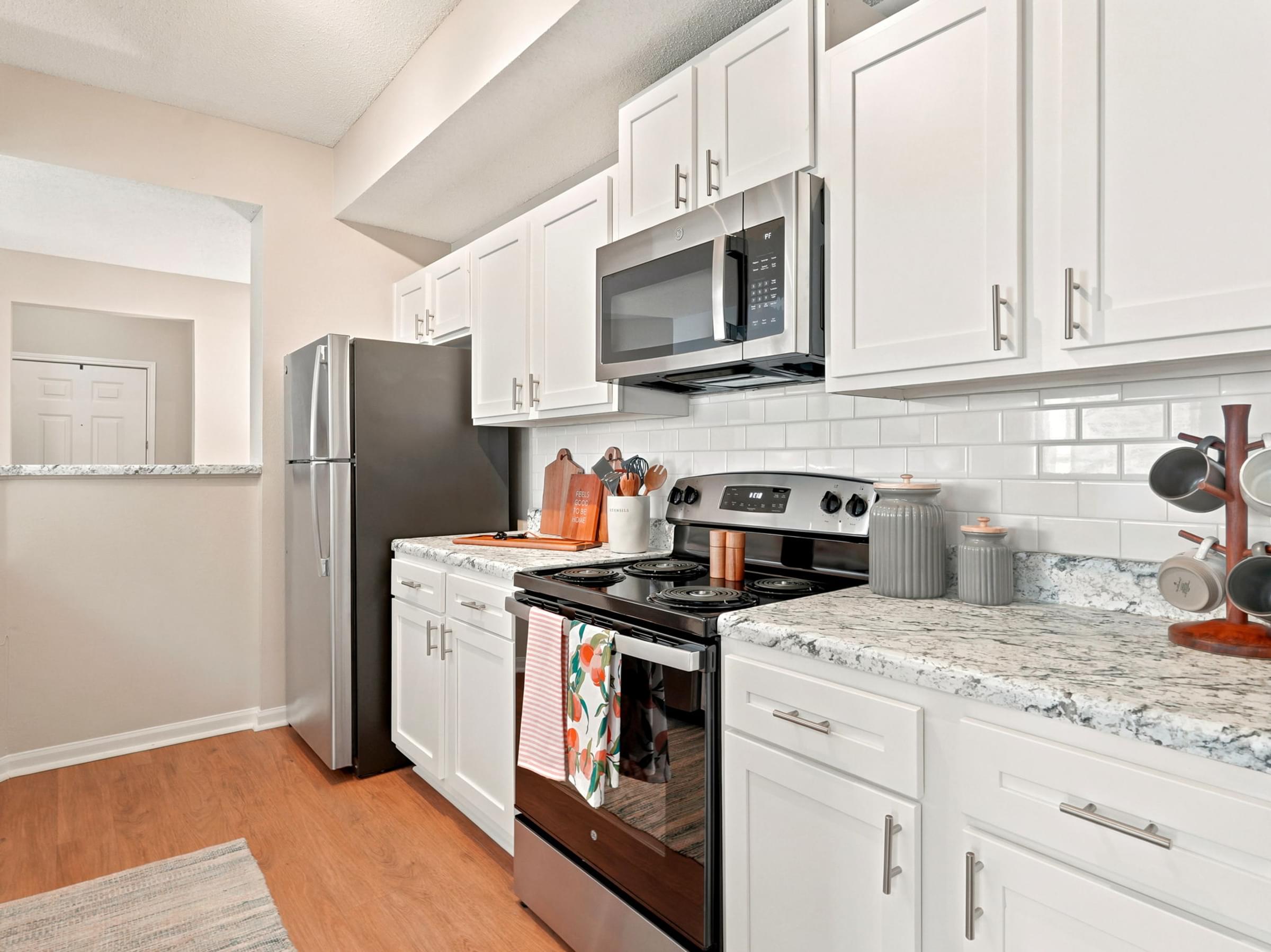 A kitchen with white cabinets and a black stove top.