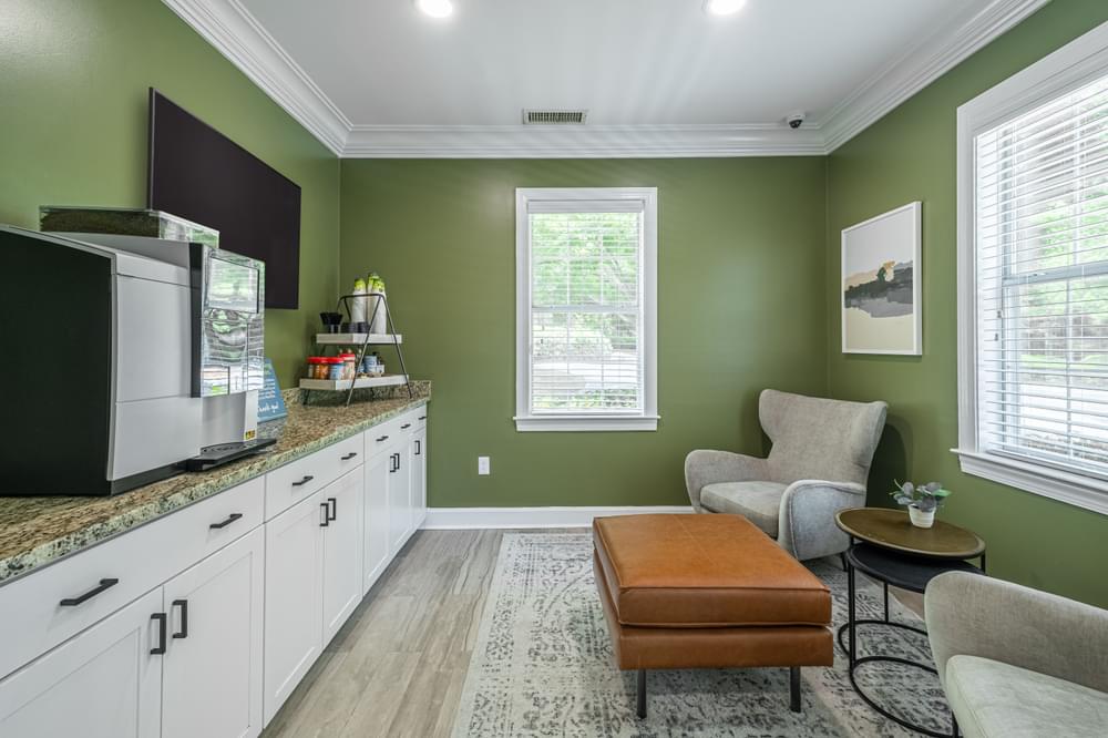 a living room with green walls and white cabinets and a television