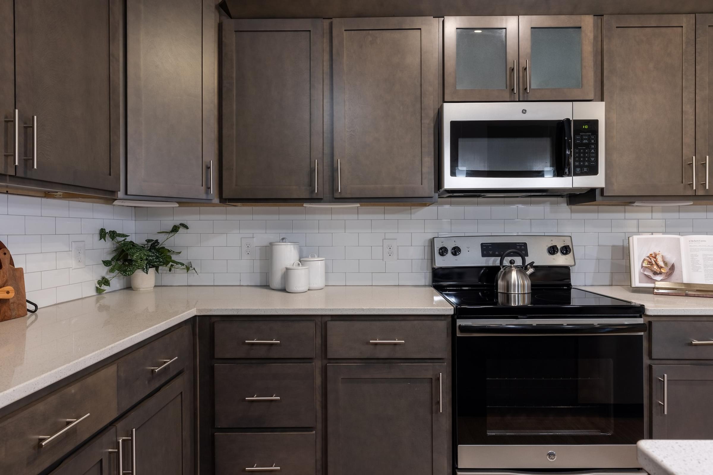 a kitchen with black appliances and brown cabinets