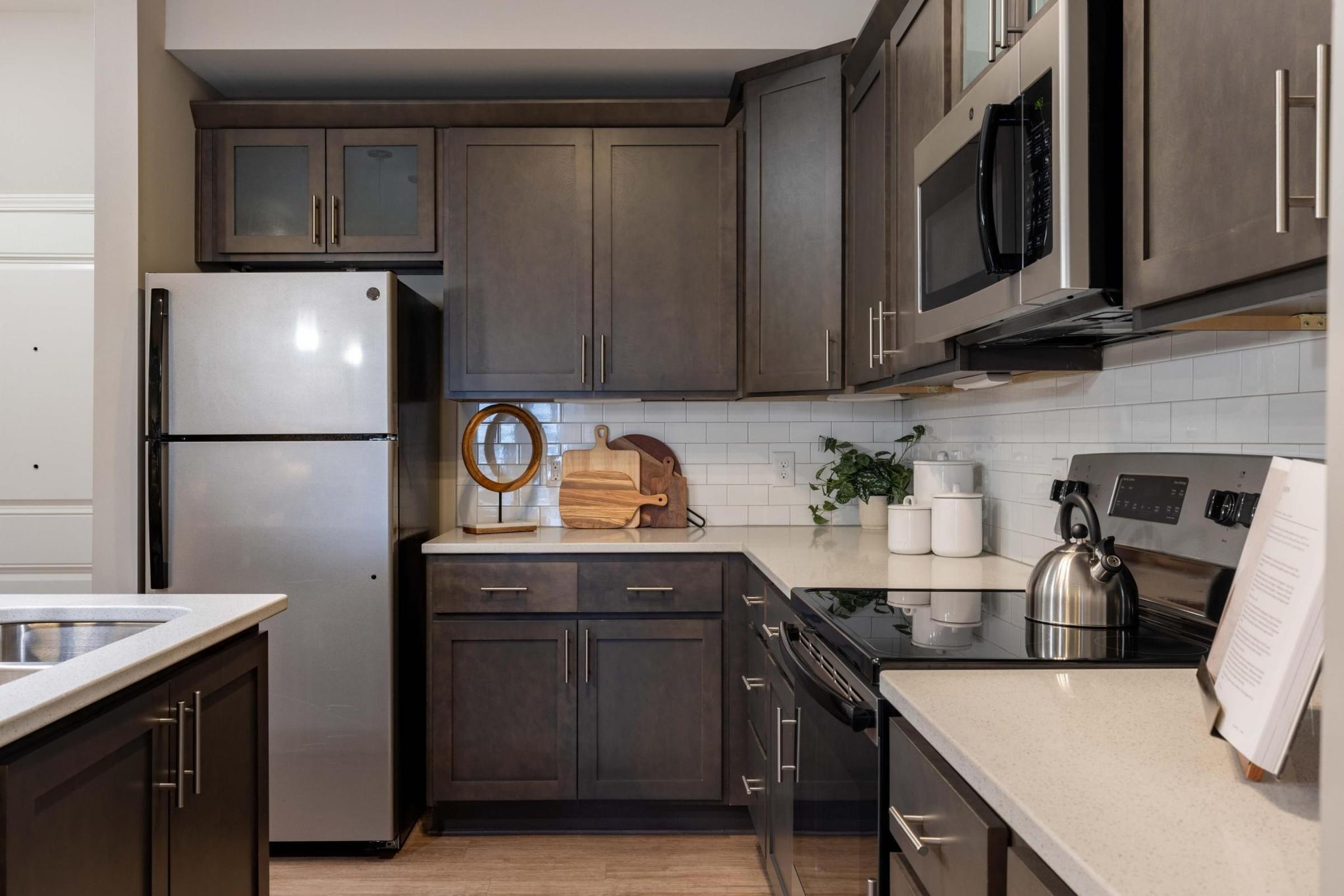 a kitchen with stainless steel appliances and dark cabinets