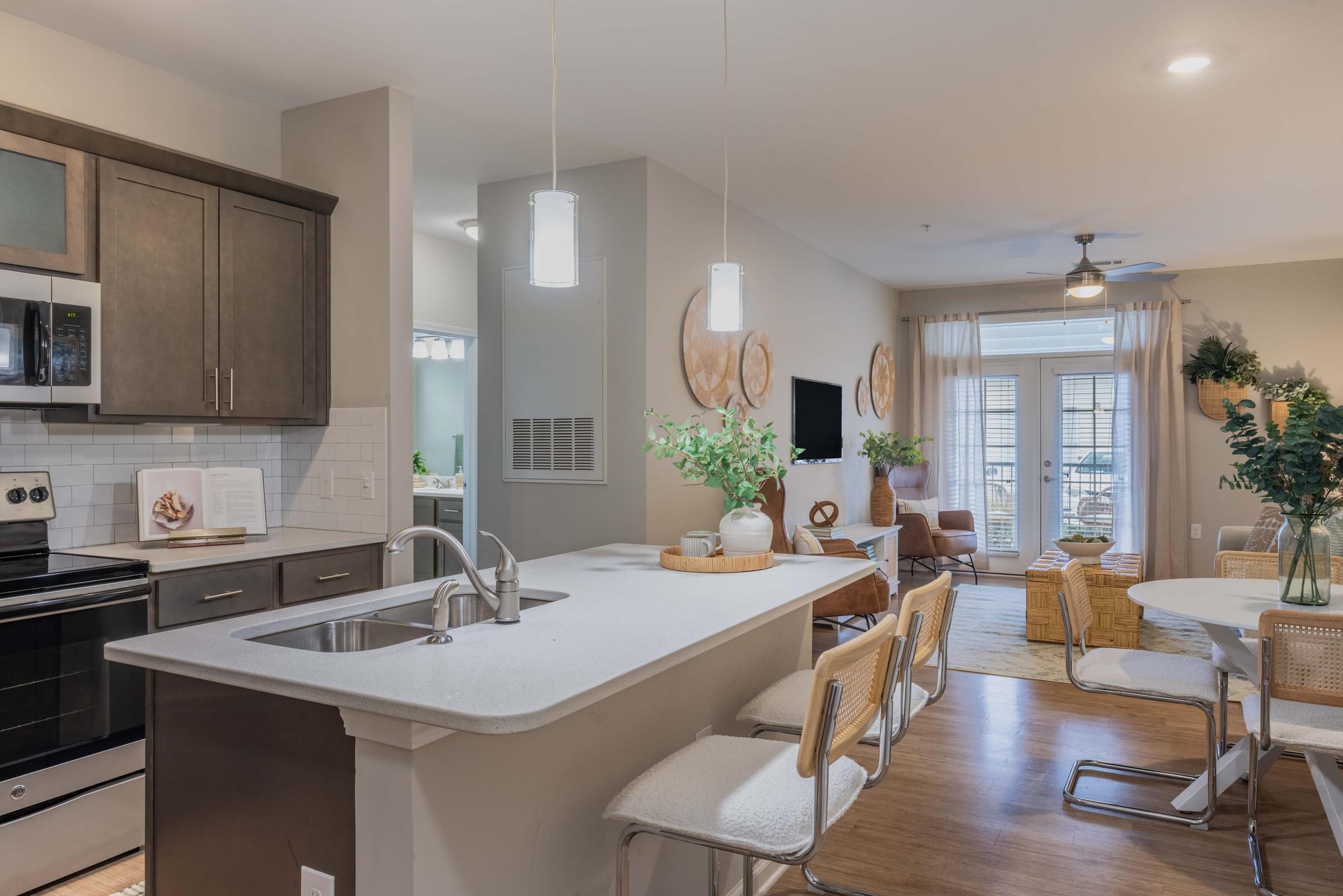 a kitchen with an island and a living room with a table and chairs