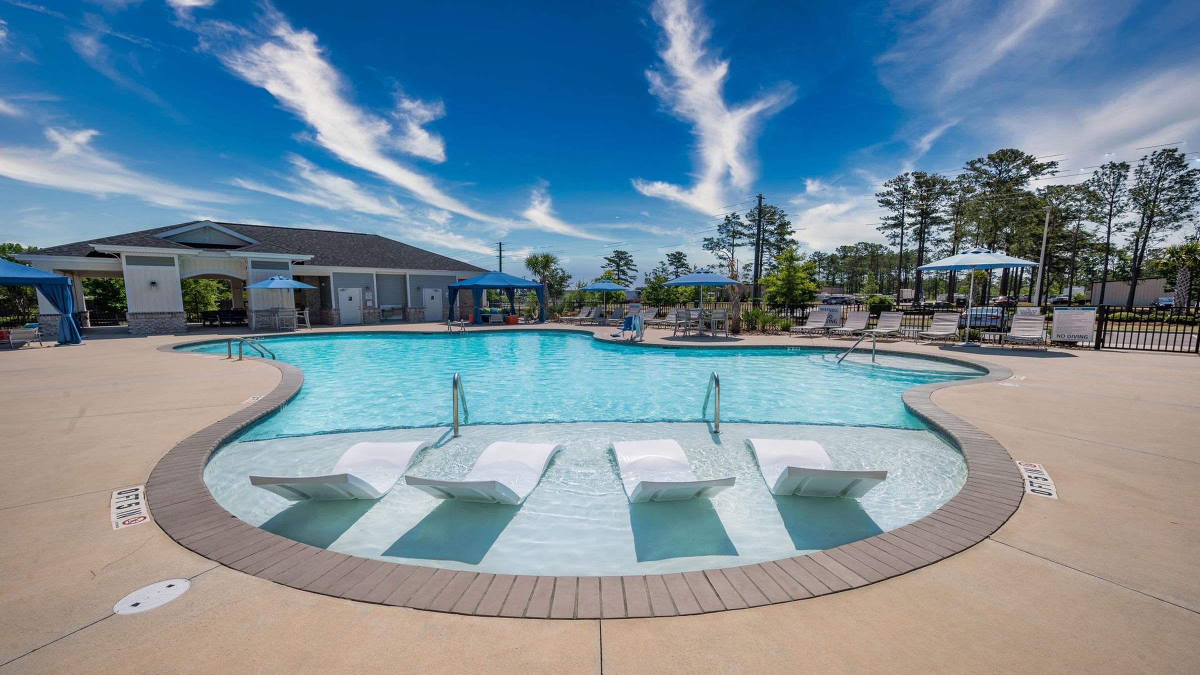 A large outdoor swimming pool with a sun lounger area.
