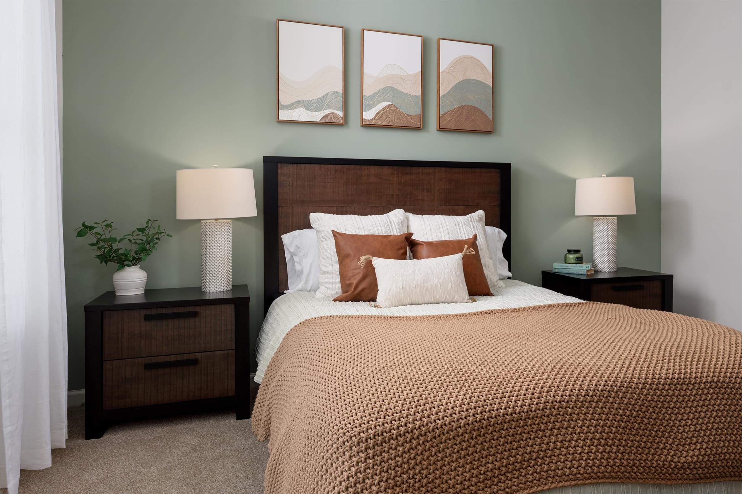 A bedroom with a large bed and two nightstands with lamps.