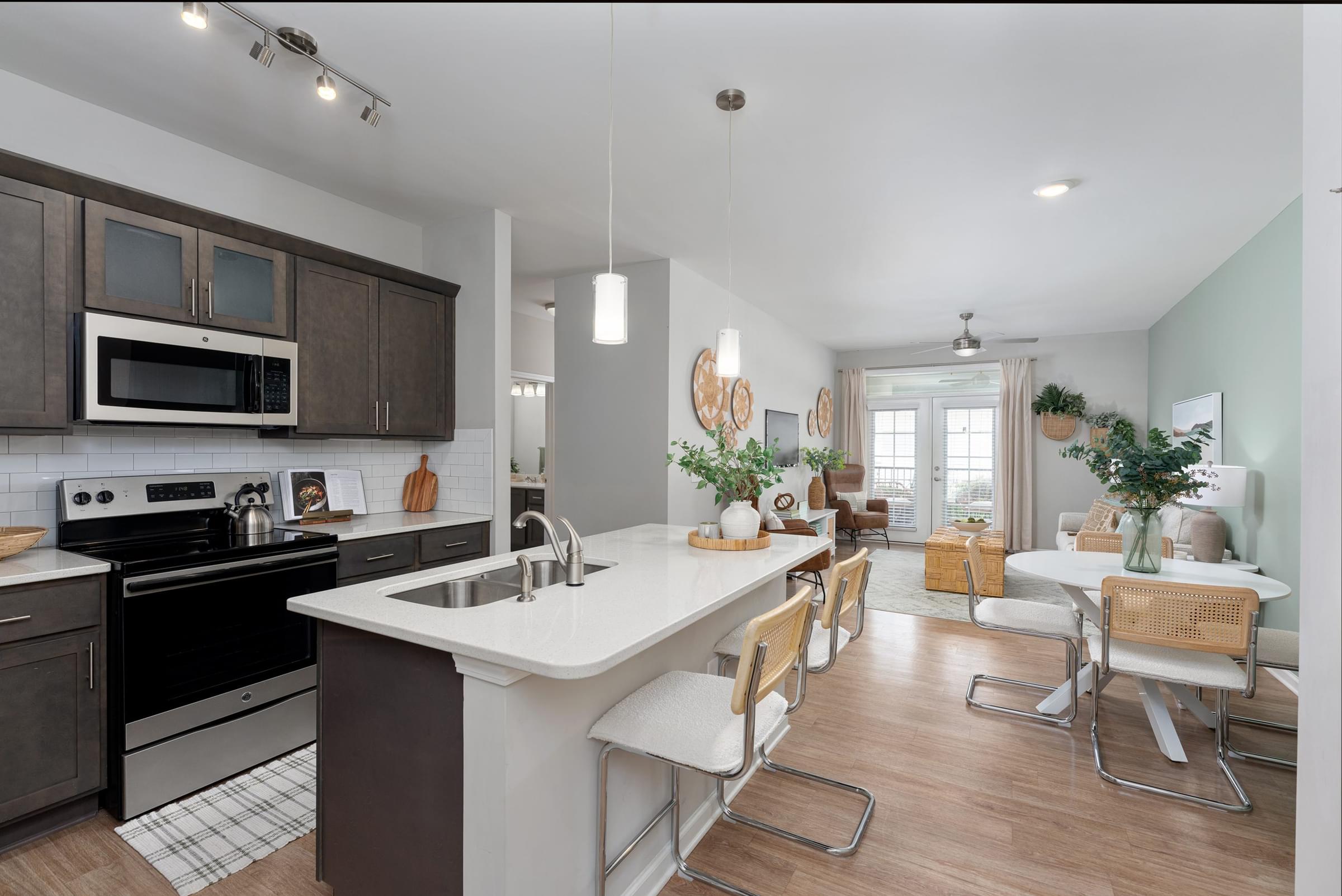 A modern kitchen with a large island and a dining area.