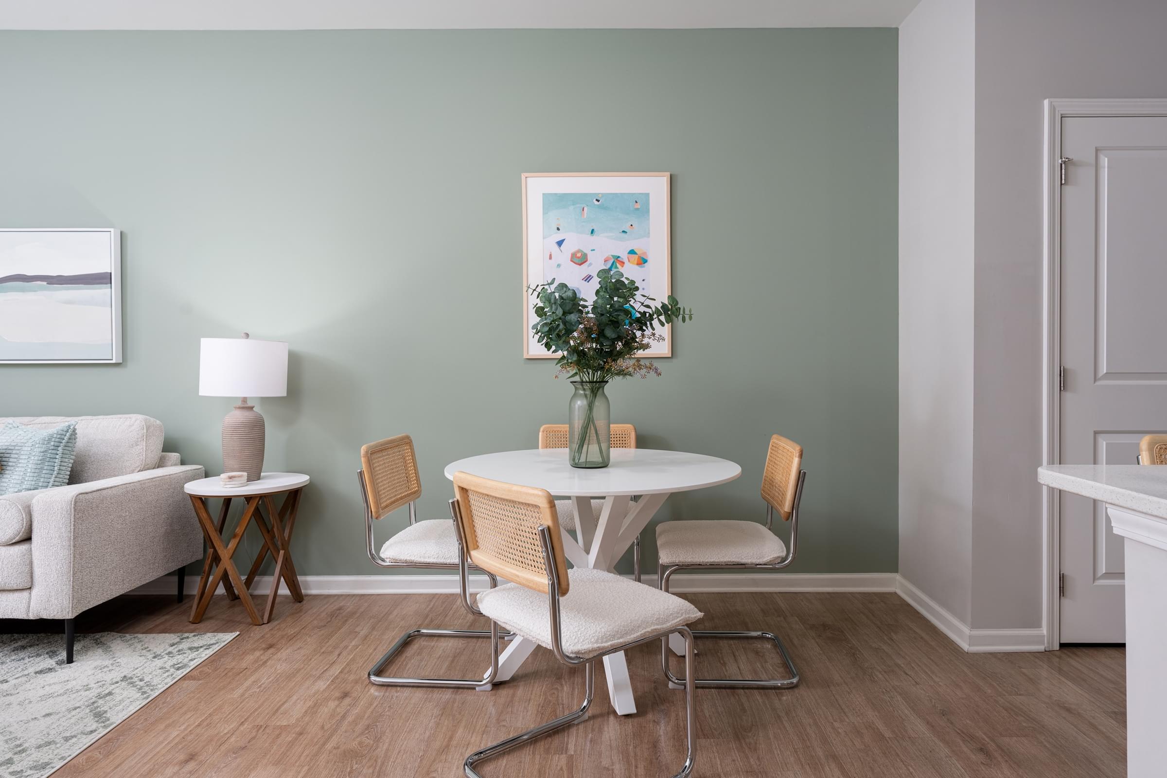A dining room with a white table and chairs.