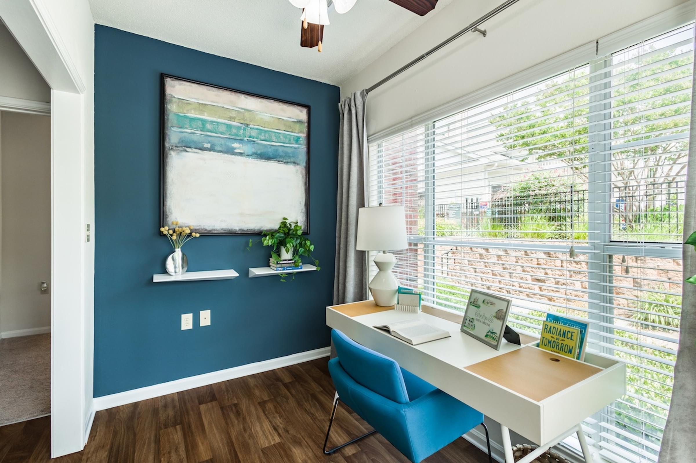 a home office with blue walls and a white desk with a blue chair