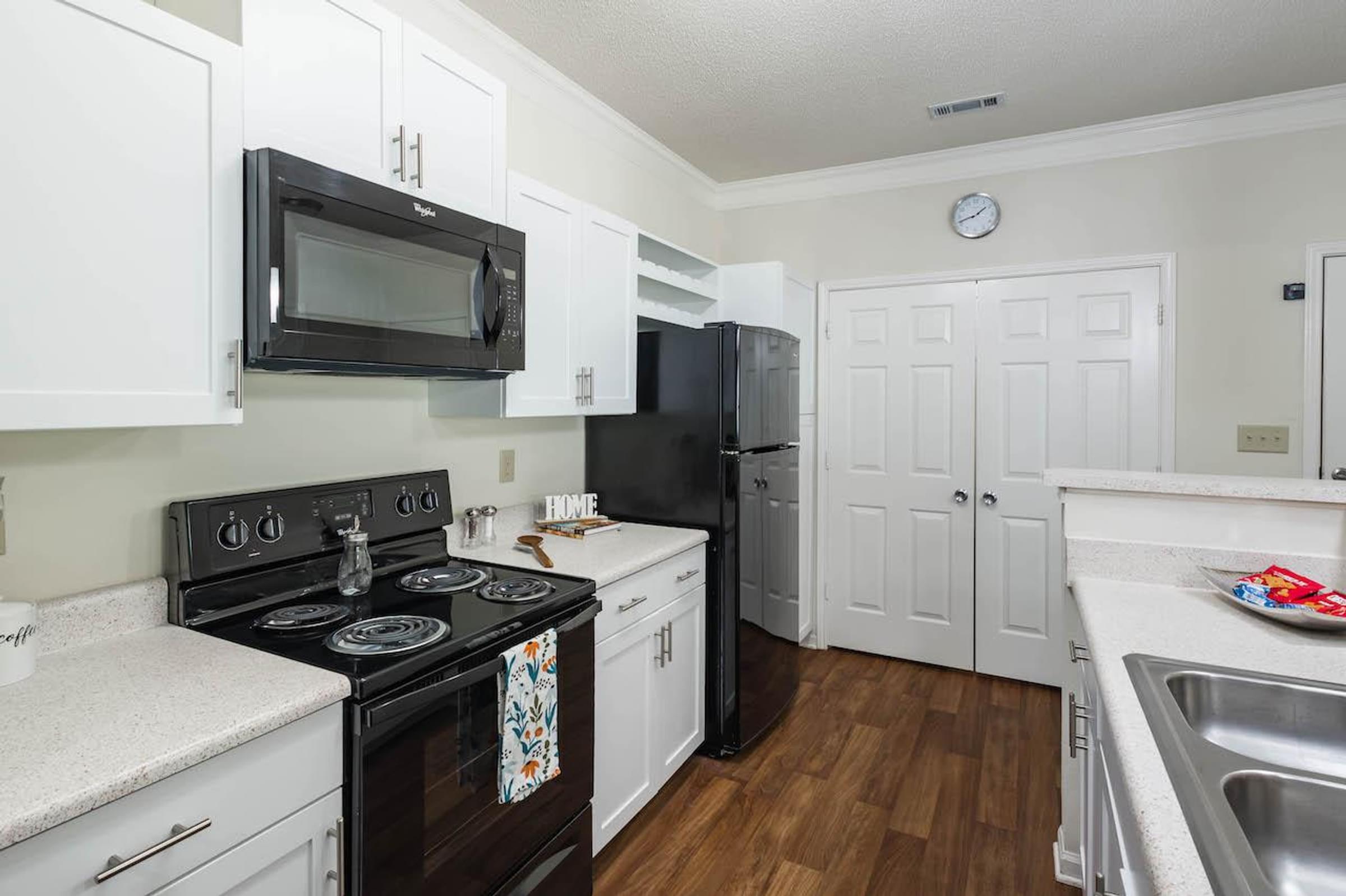 a kitchen with white cabinets and a black stove top oven