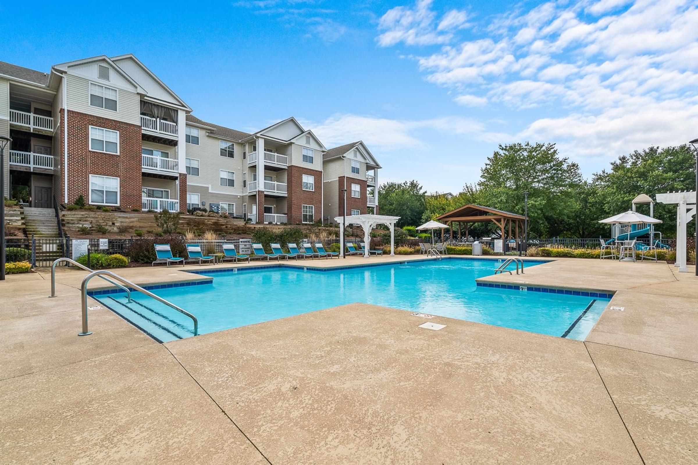 A large swimming pool in front of apartment buildings.