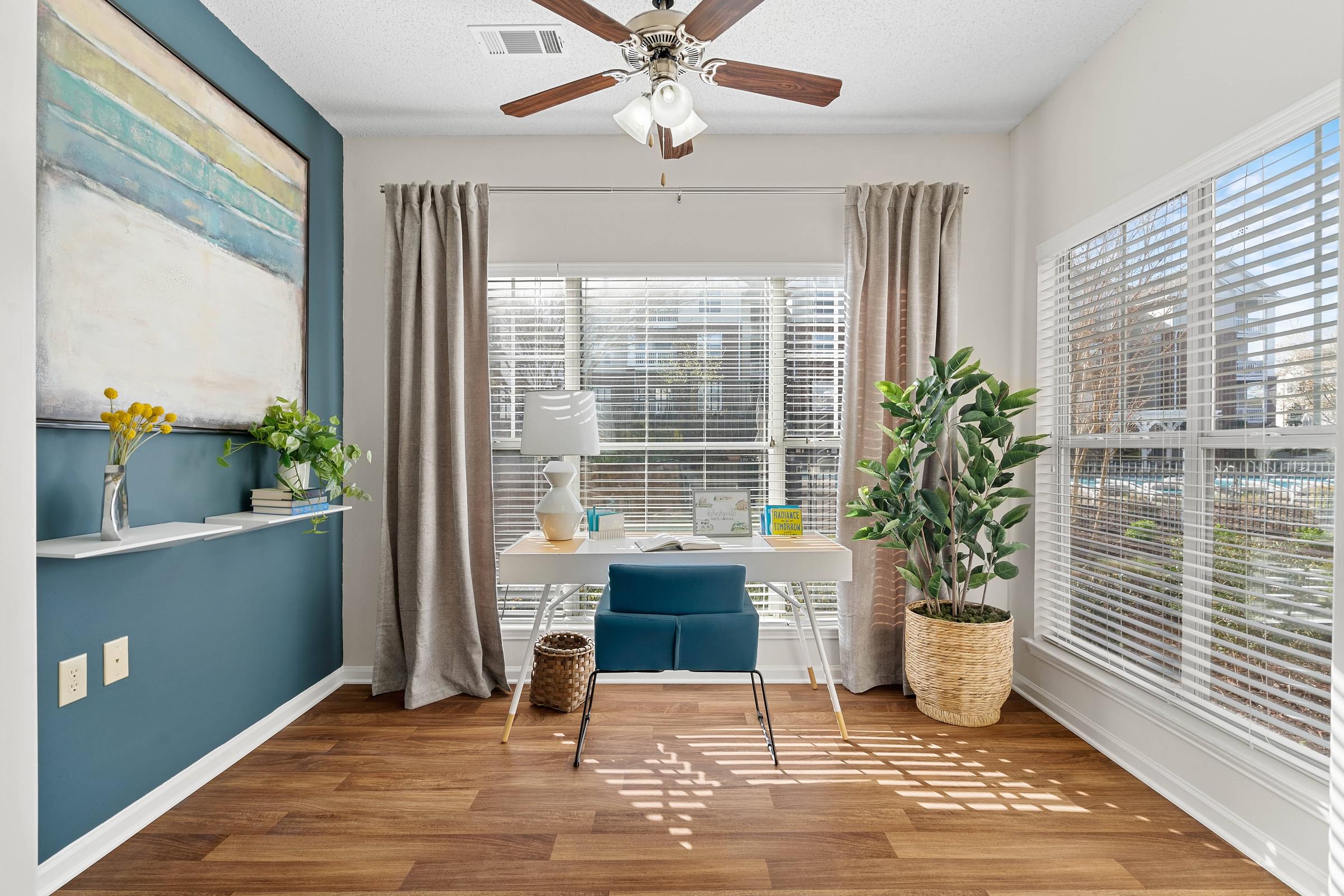 A room with a blue wall and a ceiling fan.