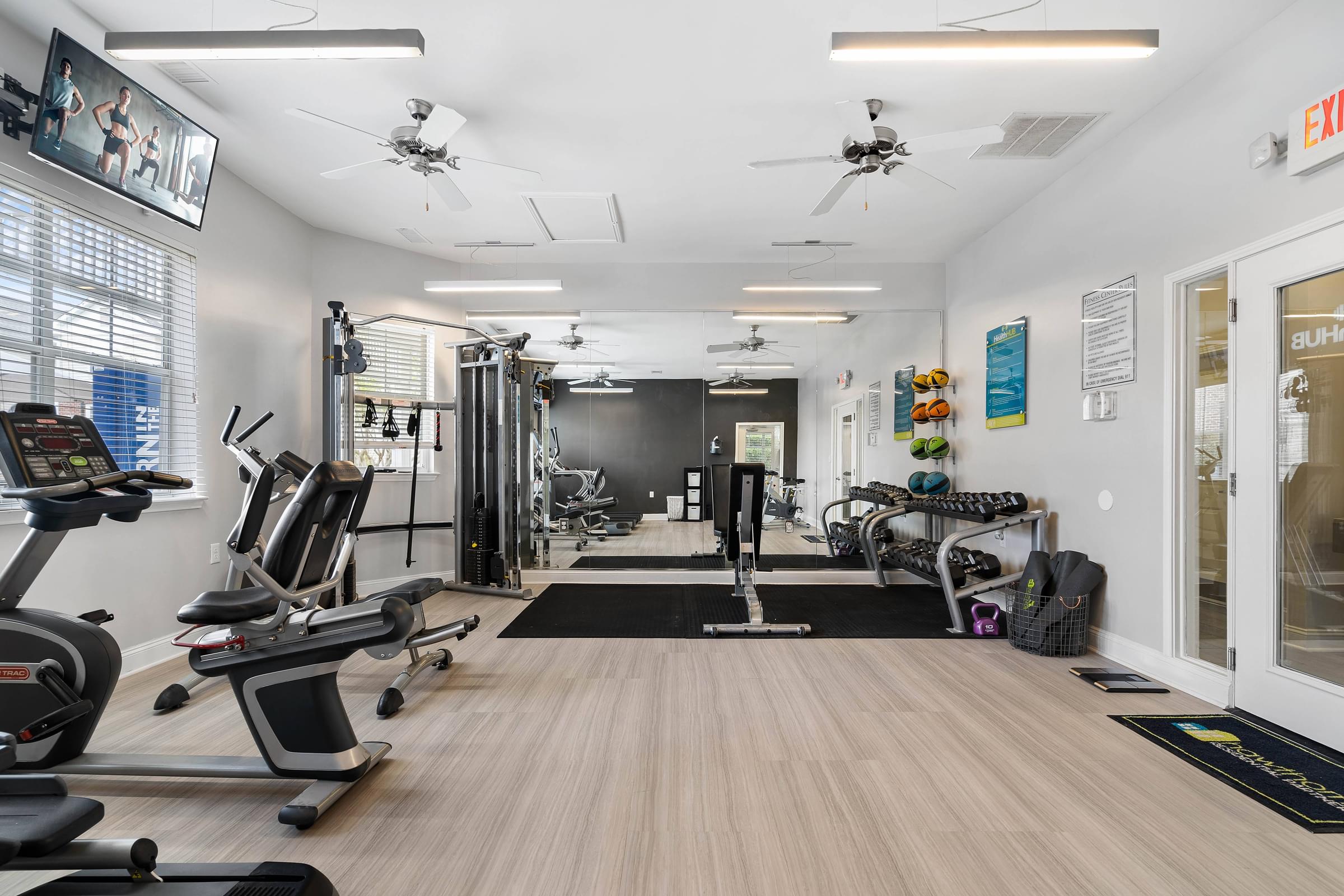 A gym with treadmills, exercise bikes, and other equipment.