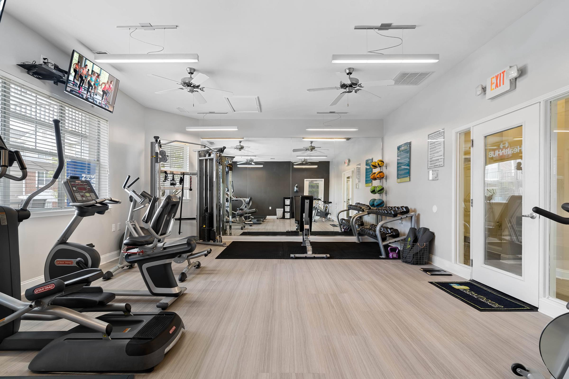 A gym with treadmills, elliptical machines, and other exercise equipment